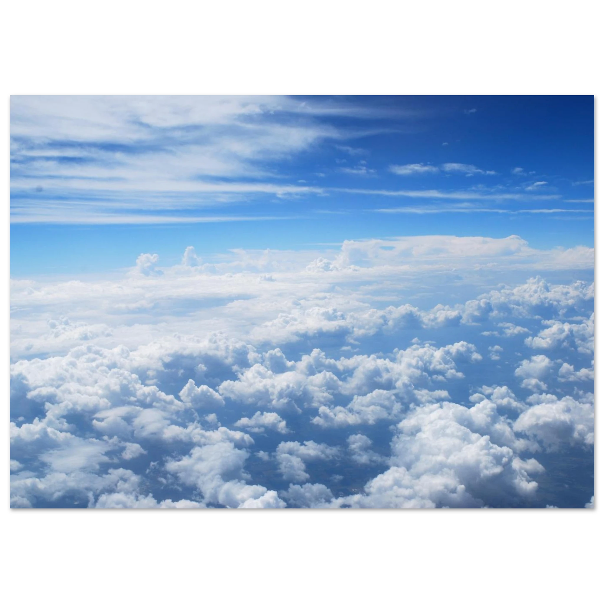 This is the 11" x 14" Above the Clouds Print by Lee Hansheng Studios. The rectangular stunning photograph of clouds captured from 36,000 feet above the earth, a breathtaking perspective that showcases the soft, ethereal beauty of the horizon. It is bright blue, dark blue, fluffs and streaks of clouds on the image. It is against a black and white background.