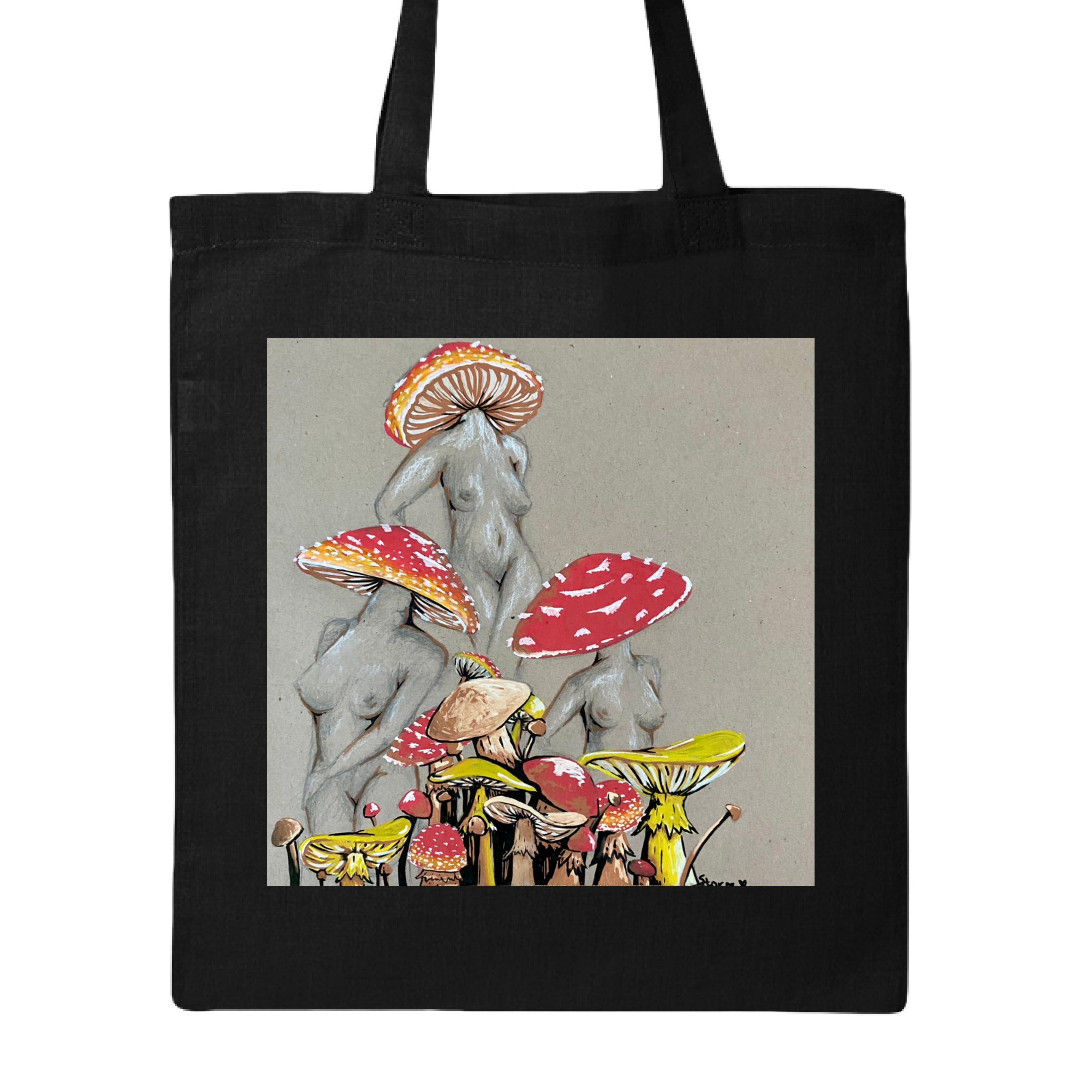 This is the Black Miss Amanita Canvas Tote by Storm Garden Studio. This is showcasing the front. This illustration is on tan/grey background. There are three fusions of female human anatomy and mushroom fungi. Their heads are different styles of mushrooms, bodies are a gray/white outlined in brown. Below are different mushrooms and shapes with a mix of tan, red, white and yellow colors. The tote handles are color matched. It is against a white background.
