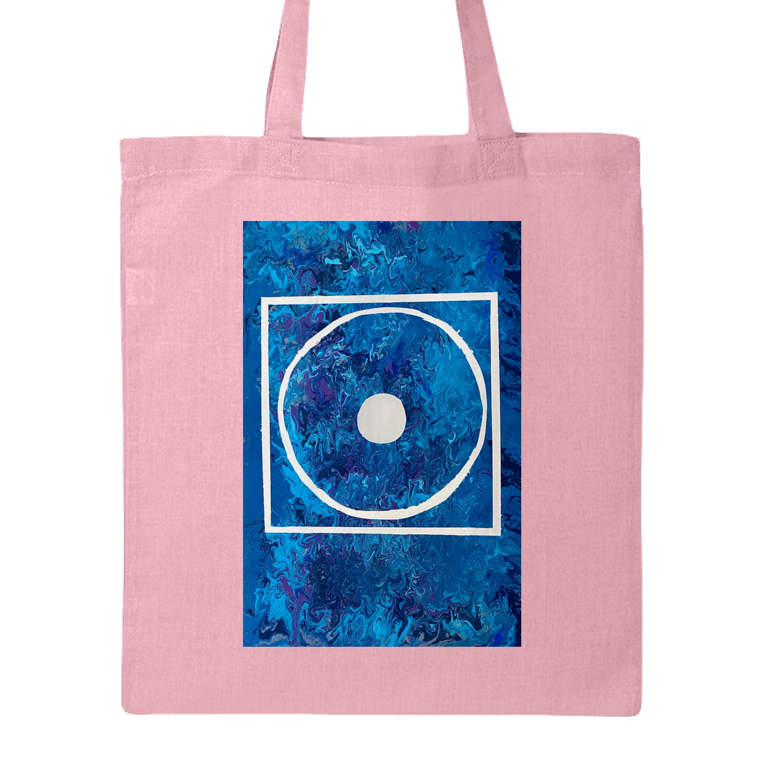 This is the Light Pink Big Low Canvas Tote by Storm Garden Studio. This is showcasing the front of the tote. The illustration is rectangular and has a white filled in dot, within a outlined circle, within a outlined rectangle. The background is a mix and dip of different blues. The tote is against a white background.