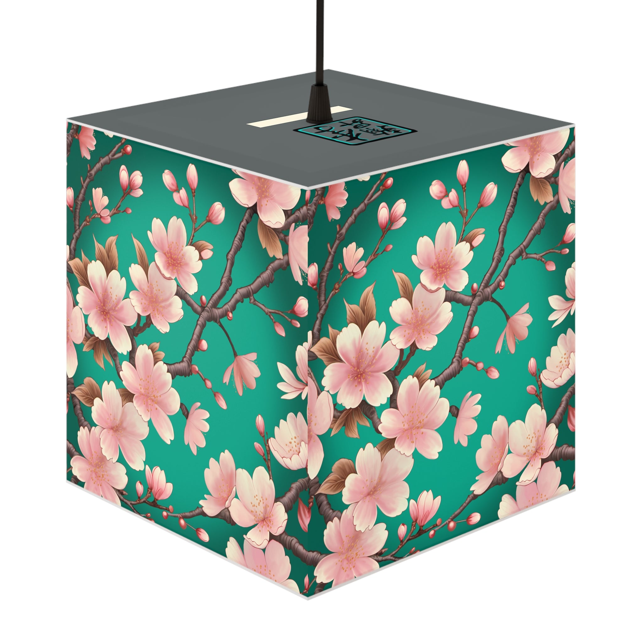 This is the Pendant Sakura Light Cube Lamp by Lee Hansheng Studios. The illustration is all around has a blue/teal background, 3-4 thin dark wood branches with pink/light pink buds on each stem. There are blooming and already flowered sakuras on each branch. There is about 3-4 inches between the end of the illustration and the sides of the lamp. The cord has a sleeker and plug-free option. The cube lamp is shown hung up. The gray top can be seen with the logo where the cord is being hung.
