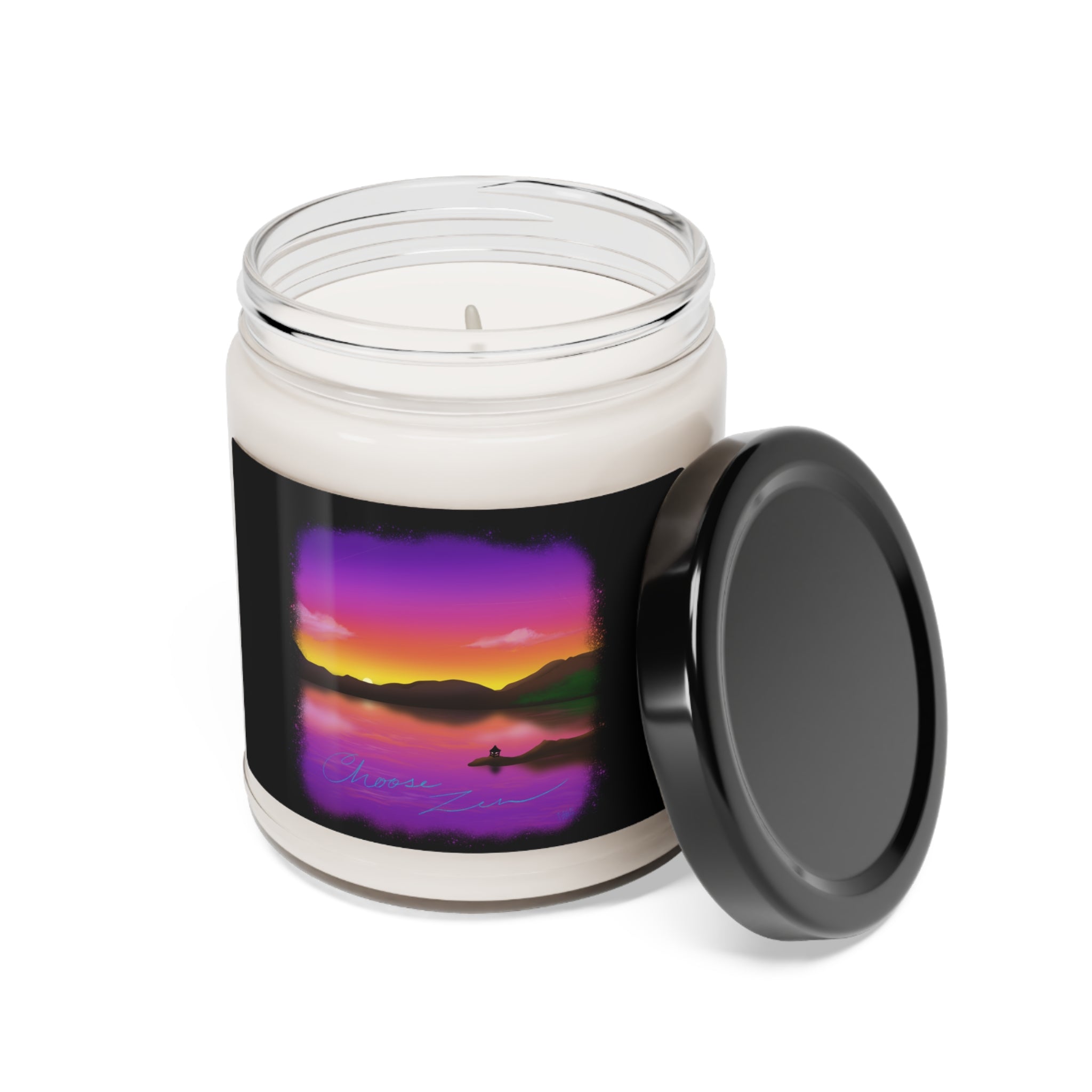 This is the Unscented Choose Zen Scented Soy Candle by Lee Hansheng Studios. The illustration is a landscape when the sun is setting from a lake.It's surrounded by black like an old time photo and phases into purple,pink,red,orange then yellow where you can see the darker green hills.The candle has a 'Choose Zen' illustration on the label in blue. The black lid off and to the right against the candle. It is against a white background.