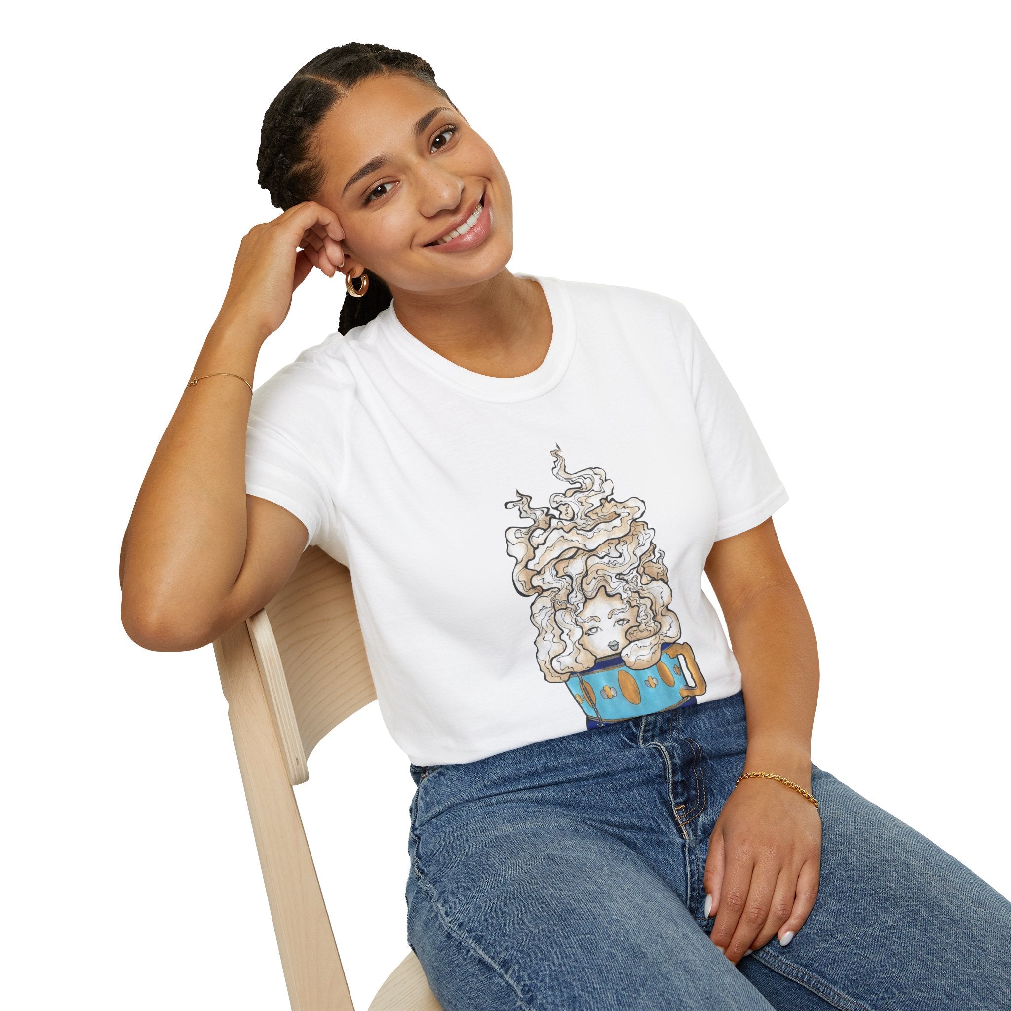 This is the White Earl Grey Softstyle T-Shirt by Chris Foster Design. It comes in sizes XS-5XL. The illustration is of a gold, light blue and dark blue teacup with a tan, yellow and white steam. The steam is swirly and goes up and outwards. In the middle is a lady's face. A smiling lady is sitting on a light wood chair with the backrest to the left, elbow on the back rest, dark jeans, looking to the front and wearing the t-shirt.