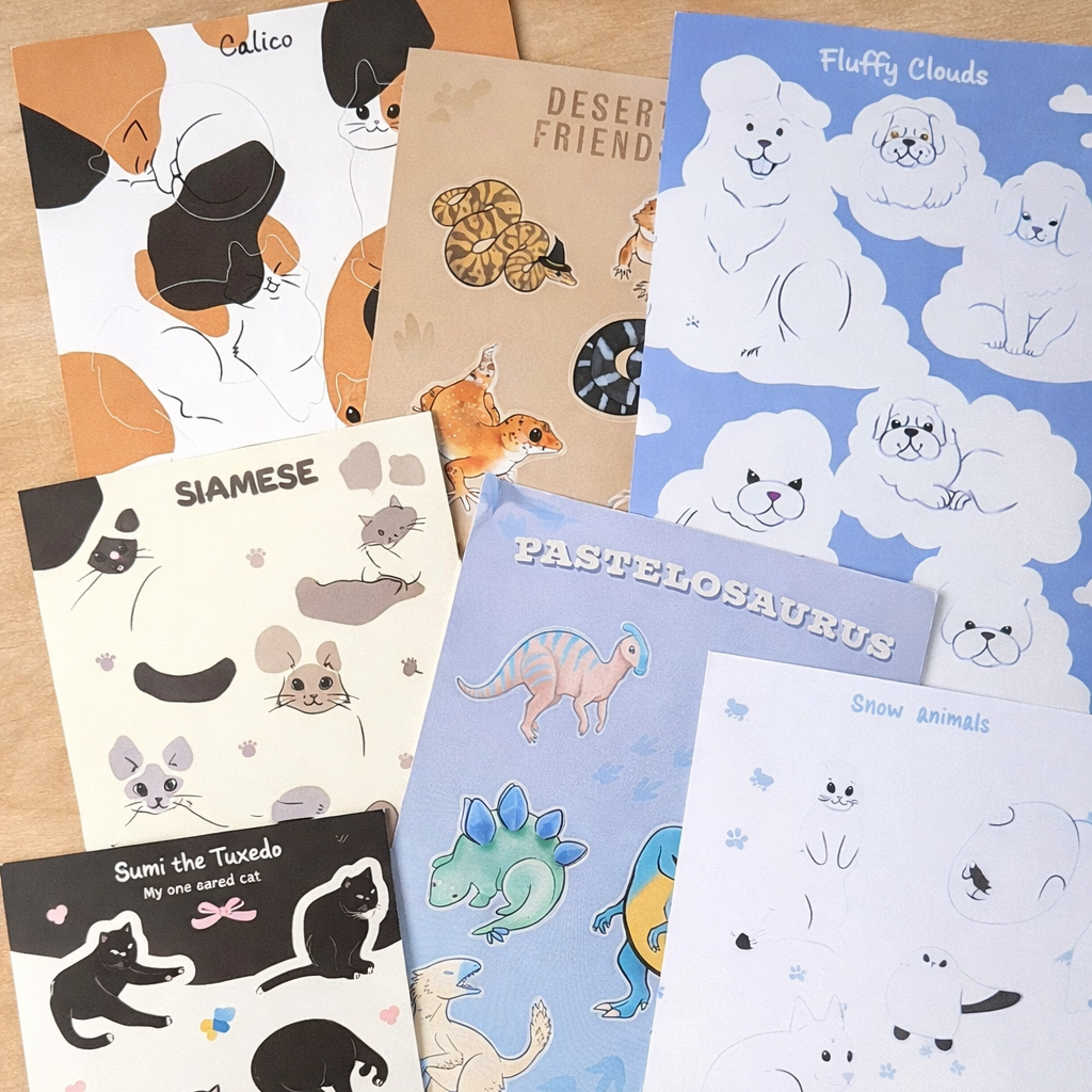 Collection of illustrated sticker sheets on a wooden surface