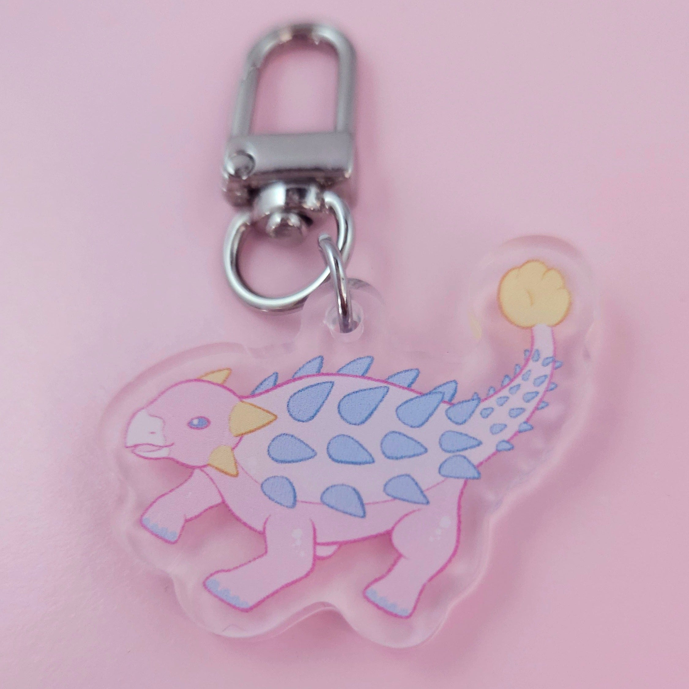 Pink ankylosaurus dinosaur keychain on a pink background