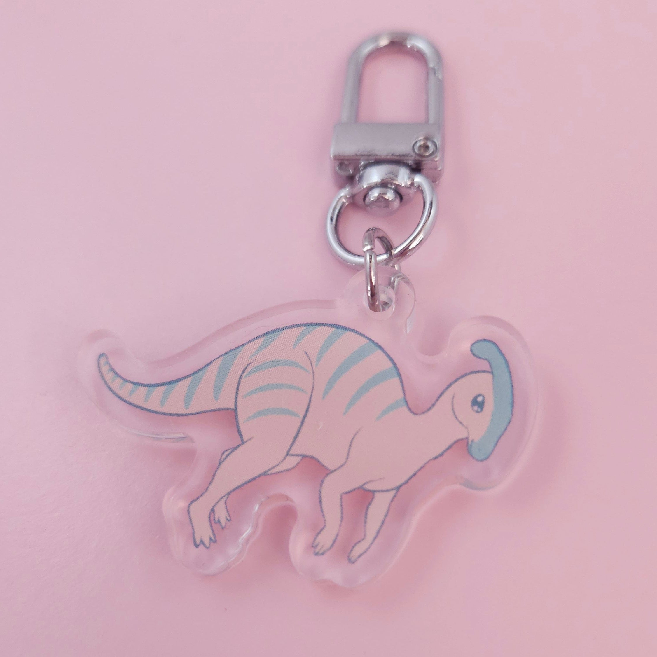 Dinosaur-shaped keychain on a pink background 1.5"