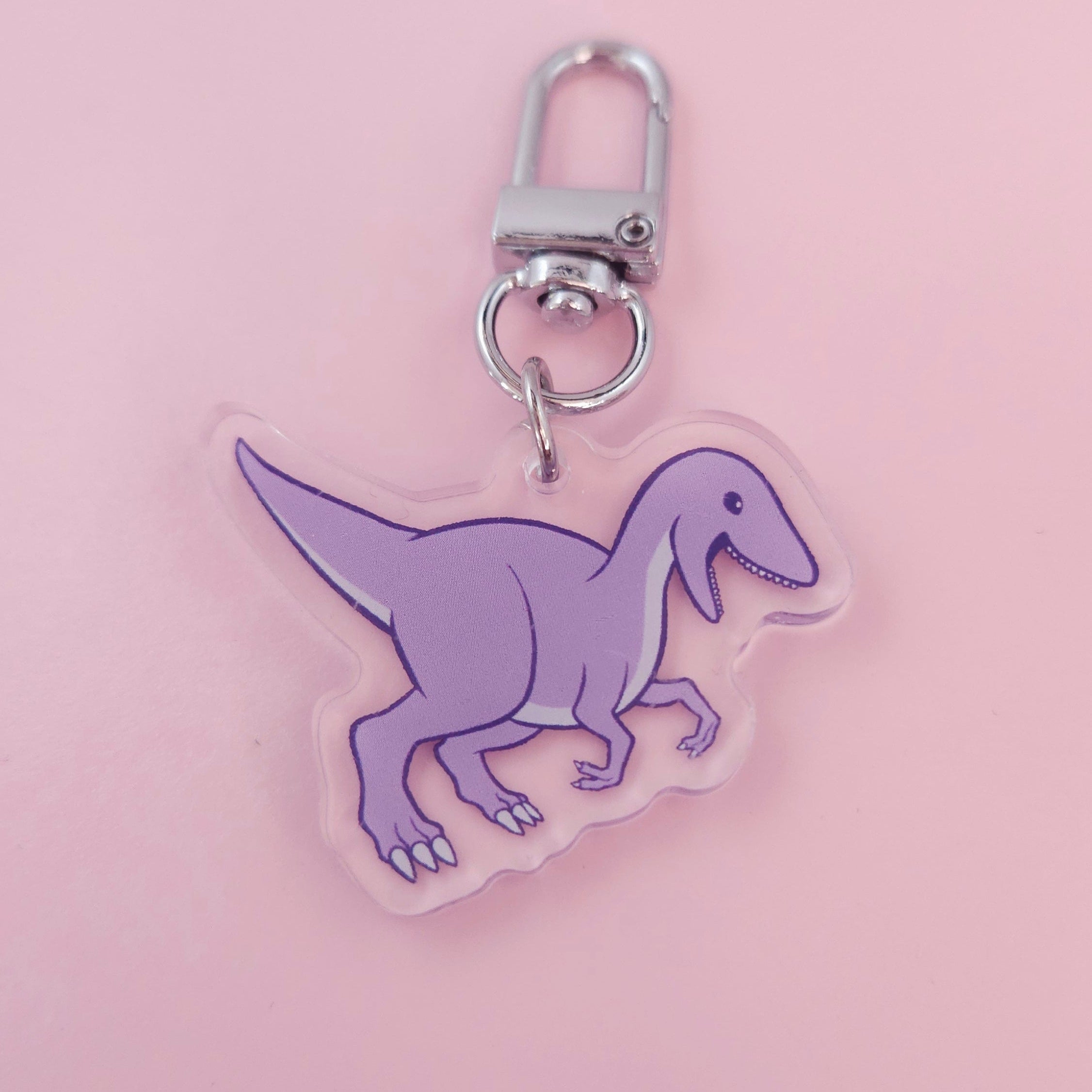 Purple dinosaur keychain on a pink background
