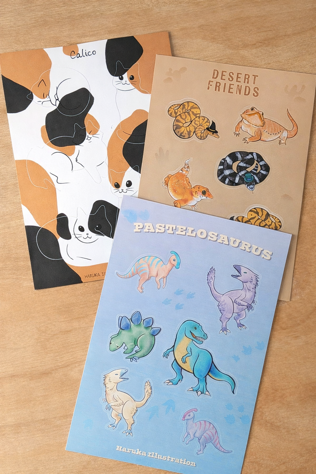 cat, reptile, and dinosaur stickers sticker sheets on a wooden table