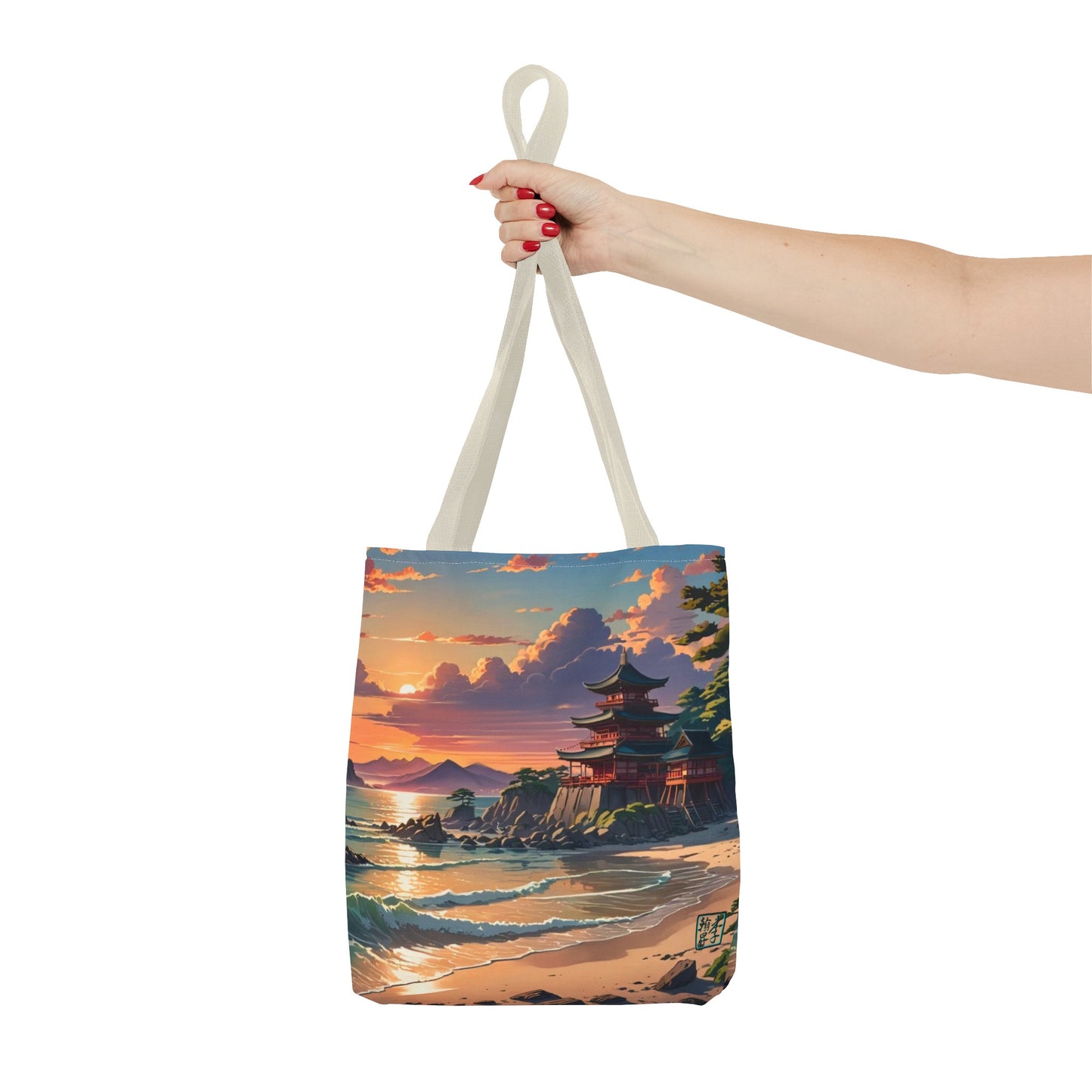 This is the Beige 13" x 13" Temple of Peace All-over Print Tote Bag by Lee Hansheng Studios.The illustration shows a setting red/orange sun above clouds,two blue roof,brown/red walled temples on the right on top of the hills,mountains,blue/white waves into sand and a forest to the right.On the bottom right corner is the logo printed in black for the studio and outlined in blue. A lady's upper arm is holding the tote from the handles to the middle from the right. She has red nailpolish on her nails. 