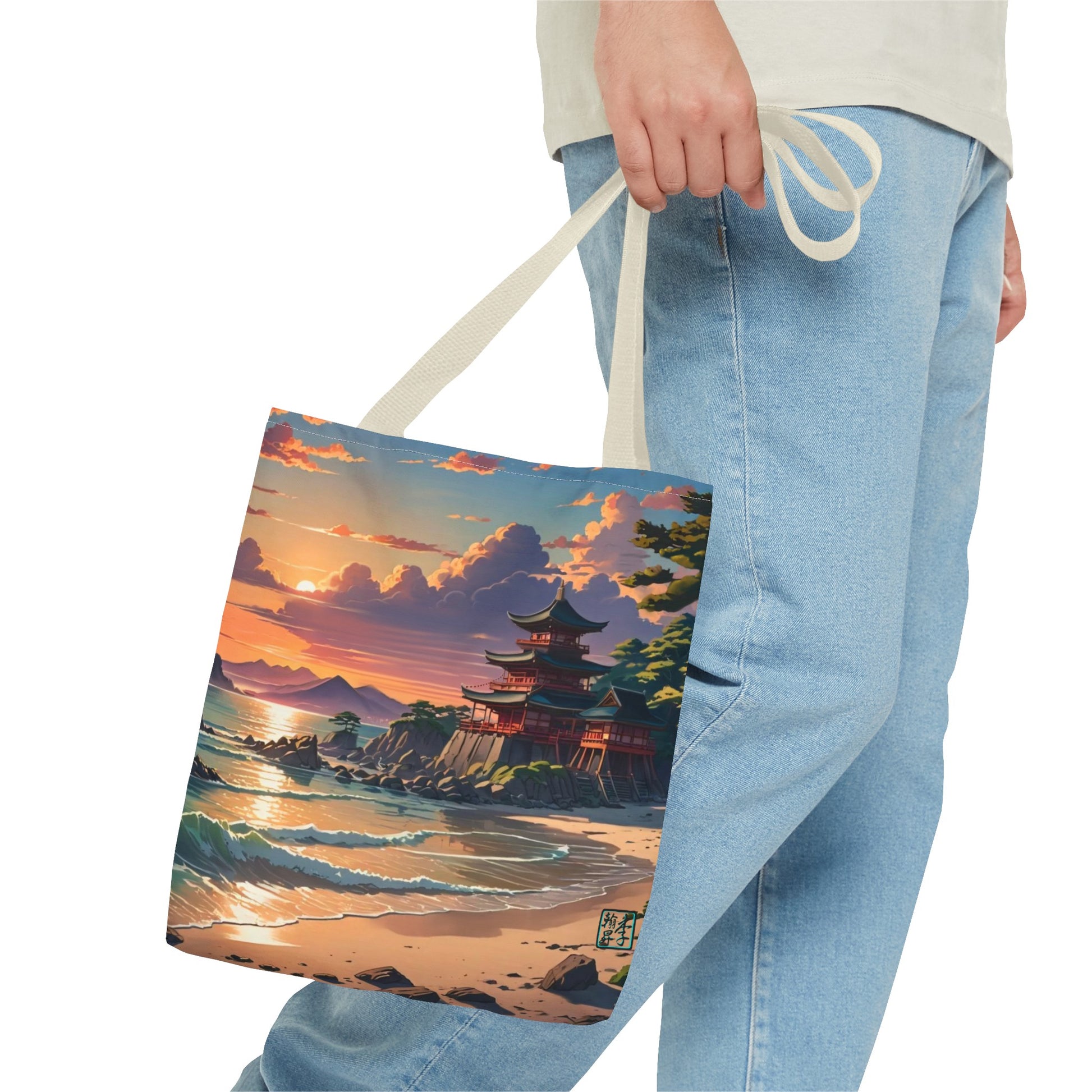 This is the Beige 16" x 16" Temple of Peace All-over Print Tote Bag by Lee Hansheng Studios.The illustration shows a setting red/orange sun above clouds,two blue roof,brown/red walled temples on the right on top of the hills,mountains,blue/white waves into sand and a forest to the right.On the bottom right corner is the logo printed in black for the studio and outlined in blue. The image is of a man wearing white tee, light jeans and right hand is holding the tote from waist down.