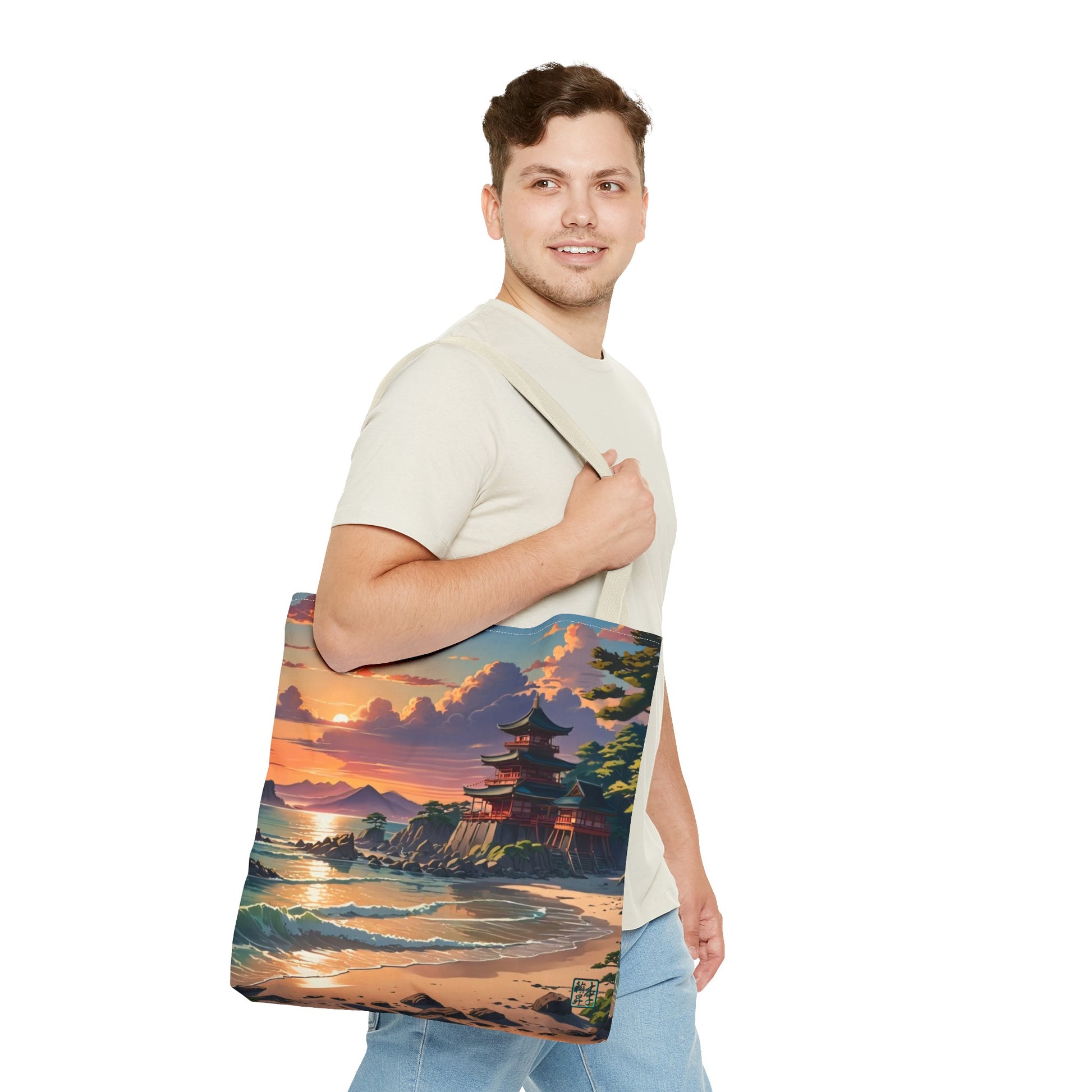 This is the Beige 18" x 18" Temple of Peace All-over Print Tote Bag by Lee Hansheng Studios.The illustration shows a setting red/orange sun above clouds,two blue roof,brown/red walled temples on the right on top of the hills,mountains,blue/white waves into sand and a forest to the right.On the bottom right corner is the logo printed in black for the studio and outlined in blue.A man with a smile, has tote over his shoulder walking right but looking left, wearing white tee,light jeans and hand on the handle.
