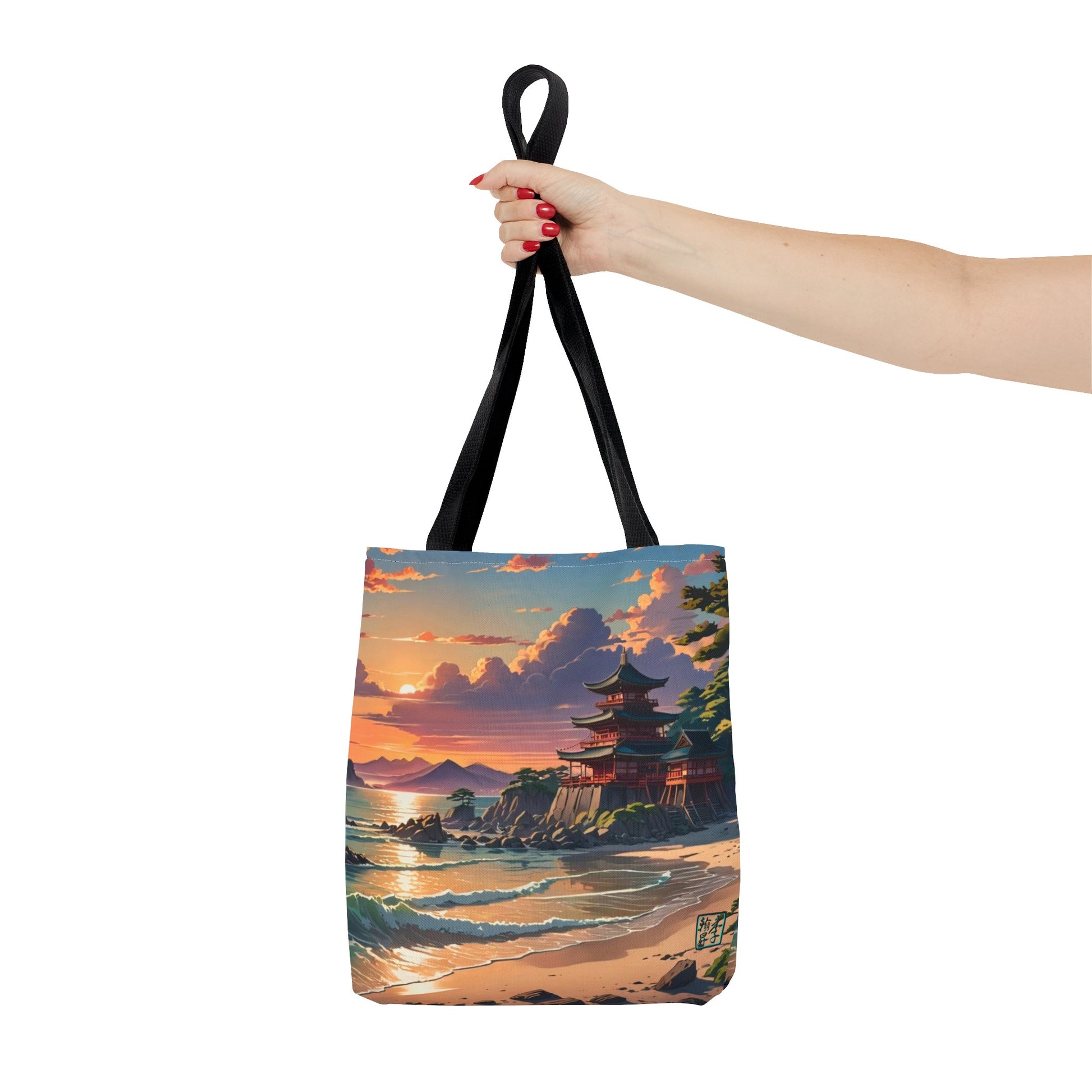 This is the Black 13" x 13" Temple of Peace All-over Print Tote Bag by Lee Hansheng Studios.The illustration shows a setting red/orange sun above clouds,two blue roof,brown/red walled temples on the right on top of the hills,mountains,blue/white waves into sand and a forest to the right.On the bottom right corner is the logo printed in black for the studio and outlined in blue. A lady's upper arm is holding the tote from the handles to the middle from the right. She has red nailpolish on her nails. 