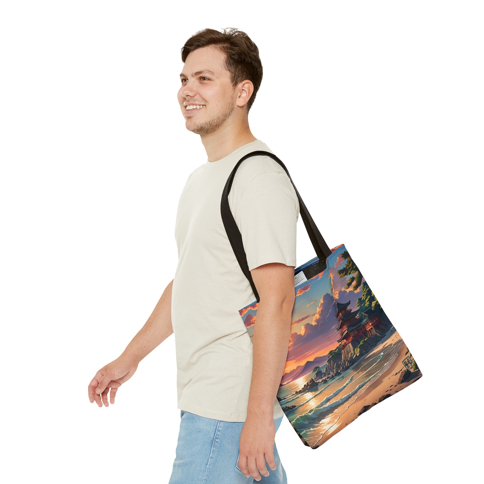 This is the Black 13" x 13" Temple of Peace All-over Print Tote Bag by Lee Hansheng Studios.The illustration shows a setting red/orange sun above clouds,two blue roof,brown/red walled temples on the right on top of the hills,mountains,blue/white waves into sand and a forest to the right.On the bottom right corner is the logo printed in black for the studio and outlined in blue. A man walking to the left, smiling, wearing white tee, light jeans with tote hanging on his shoulder and swinging his arms.