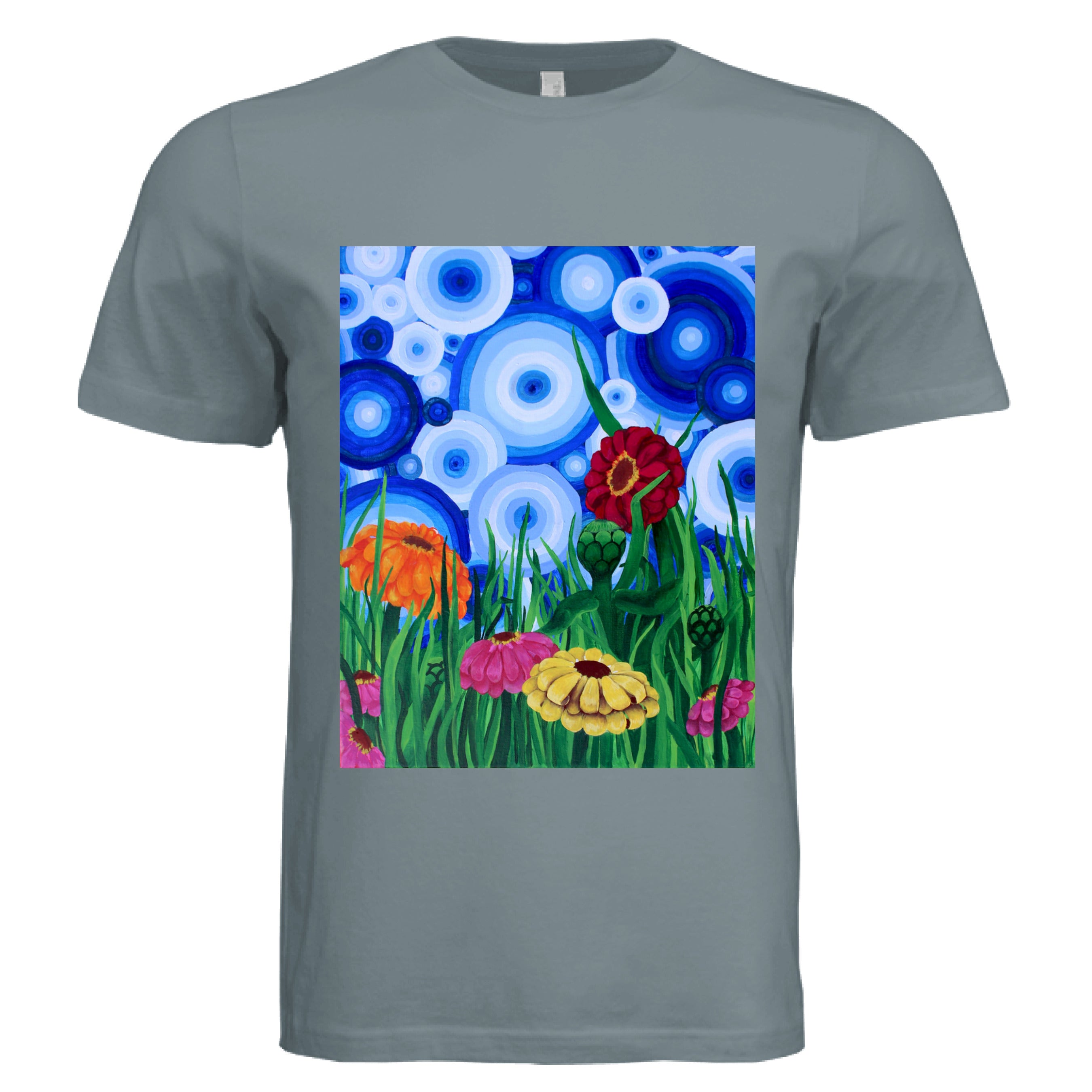 This is the Blue Storm Zinnia 2 T-Shirt by Storm Garden Studio. This showcases the front of the shirt. The rectangular illustration are bold and color zinnias like red, yellow and orange across tall green grass. The background has many different circles in blue, dark blue and white. The shirt is against a white background.