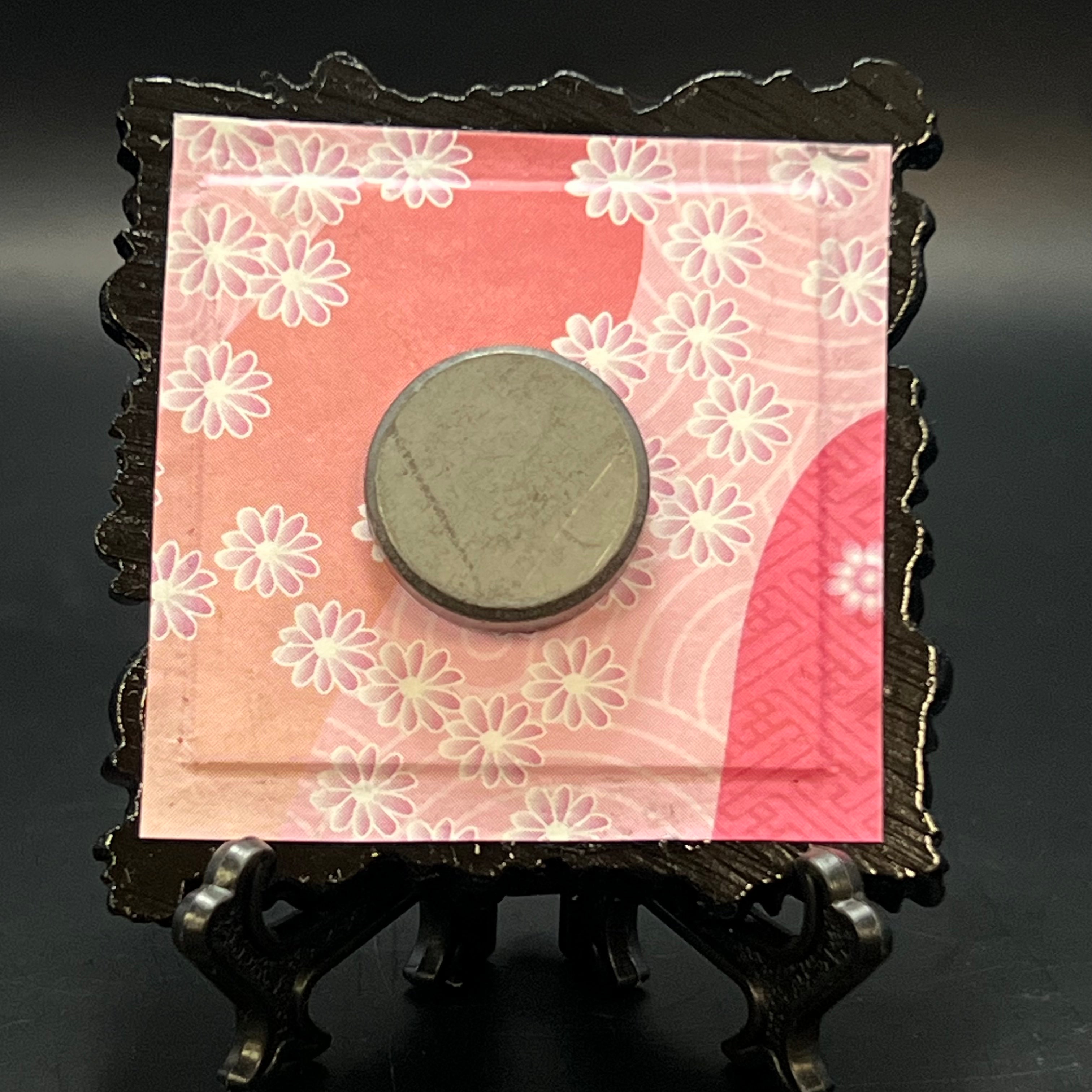This is the Cherry Blossom Branch Square Mini Painting by Chris Foster Design. This is showcasing the back. Backed with dark to light pink gradient floral Japanese origami paper. It is against a dark background.