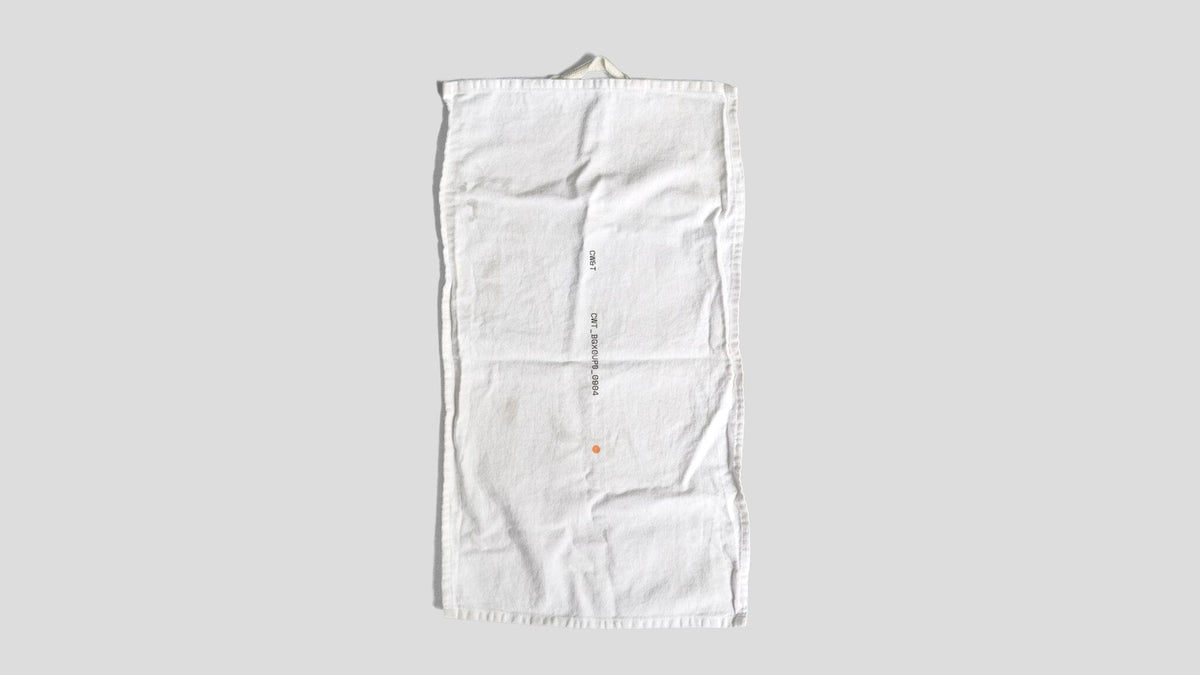 This is the clean rag against a gray/white background. It has a small handle on it, with lettering and numbers as well as a small orange dot below the writing. 