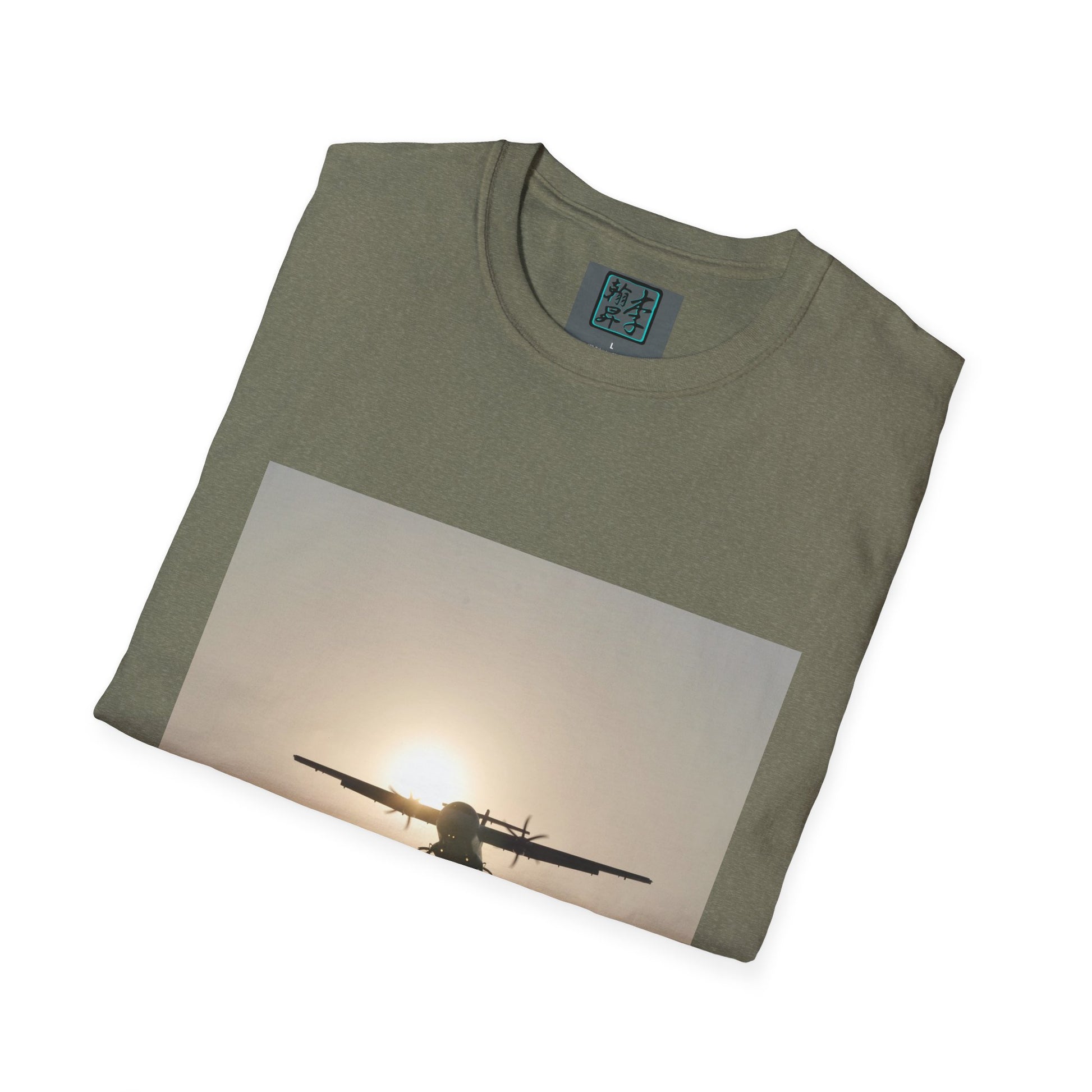 This is the Heather Military Green Landing T-Shirt by Lee Hansheng Studios. This is an image of the front folded. On the inside of the shirt is the logo for the studio printed in black outlined in blue, gray size label with the print being white. The illustration is a rectangular design of an airplane landing. There is an orange/yellow sun with the shadowed plane. The shirt is against a white background.