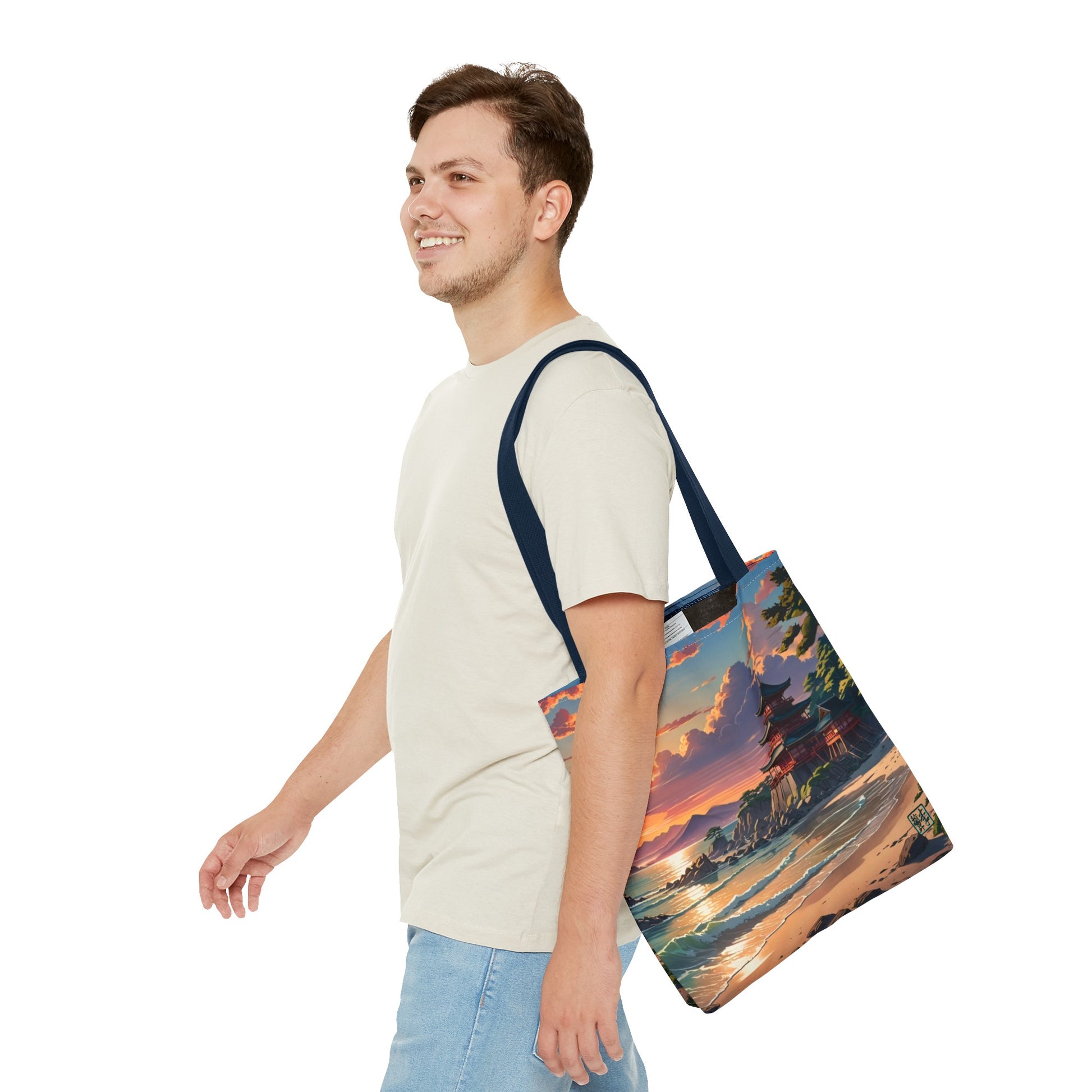 This is the Navy 13" x 13" Temple of Peace All-over Print Tote Bag by Lee Hansheng Studios.The illustration shows a setting red/orange sun above clouds,two blue roof,brown/red walled temples on the right on top of the hills,mountains,blue/white waves into sand and a forest to the right.On the bottom right corner is the logo printed in black for the studio and outlined in blue. A man walking to the left, smiling, wearing white tee, light jeans with tote hanging on his shoulder and swinging his arms.