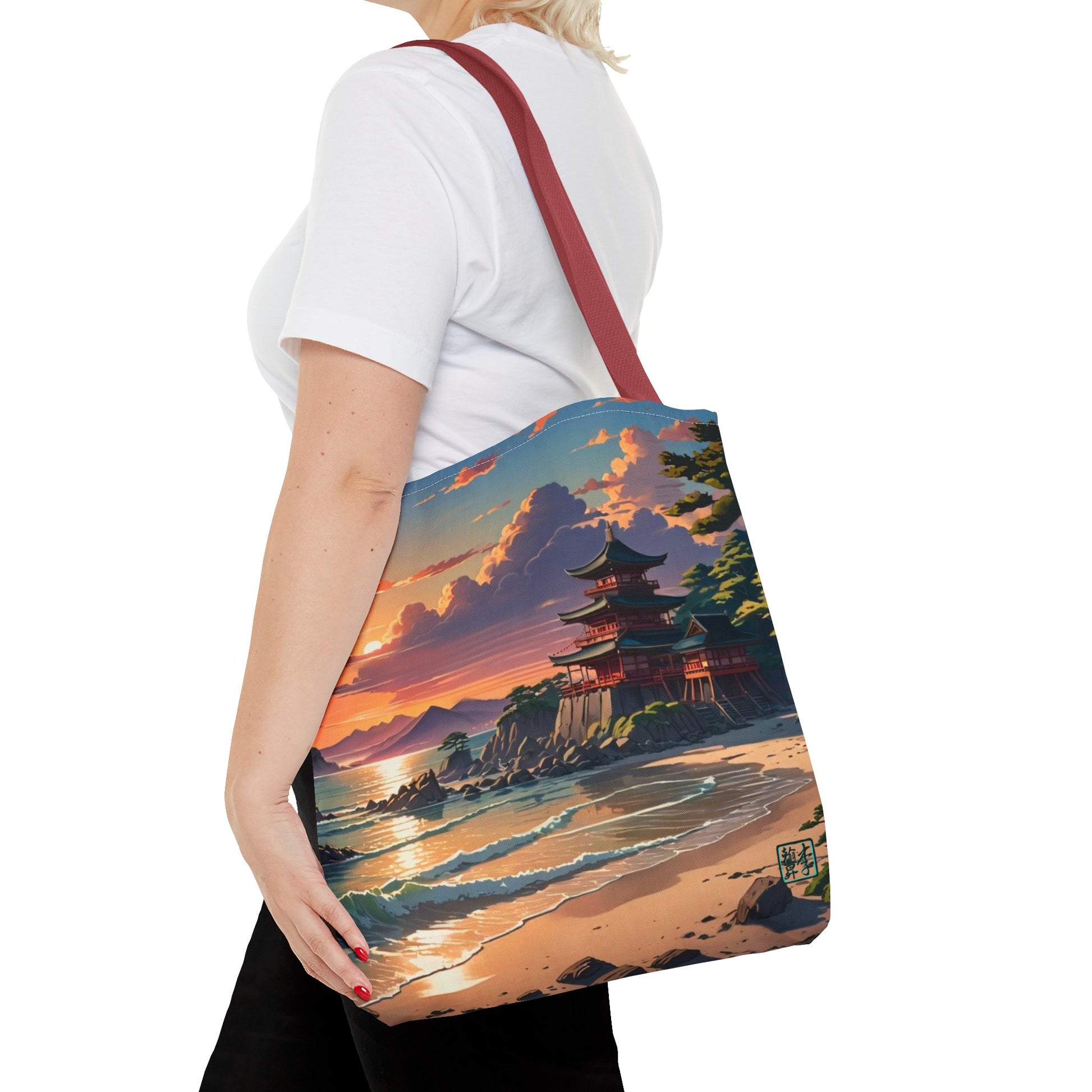 This is the Red 16" x 16" Temple of Peace All-over Print Tote Bag by Lee Hansheng Studios.The illustration shows a setting red/orange sun above clouds,two blue roof,brown/red walled temples on the right on top of the hills,mountains,blue/white waves into sand and a forest to the right.On the bottom right corner is the logo printed in black for the studio and outlined in blue.A lady carries the tote from the shoulder,a white tee,blond short hair,her hand in the black pants pocket walking towards the left.