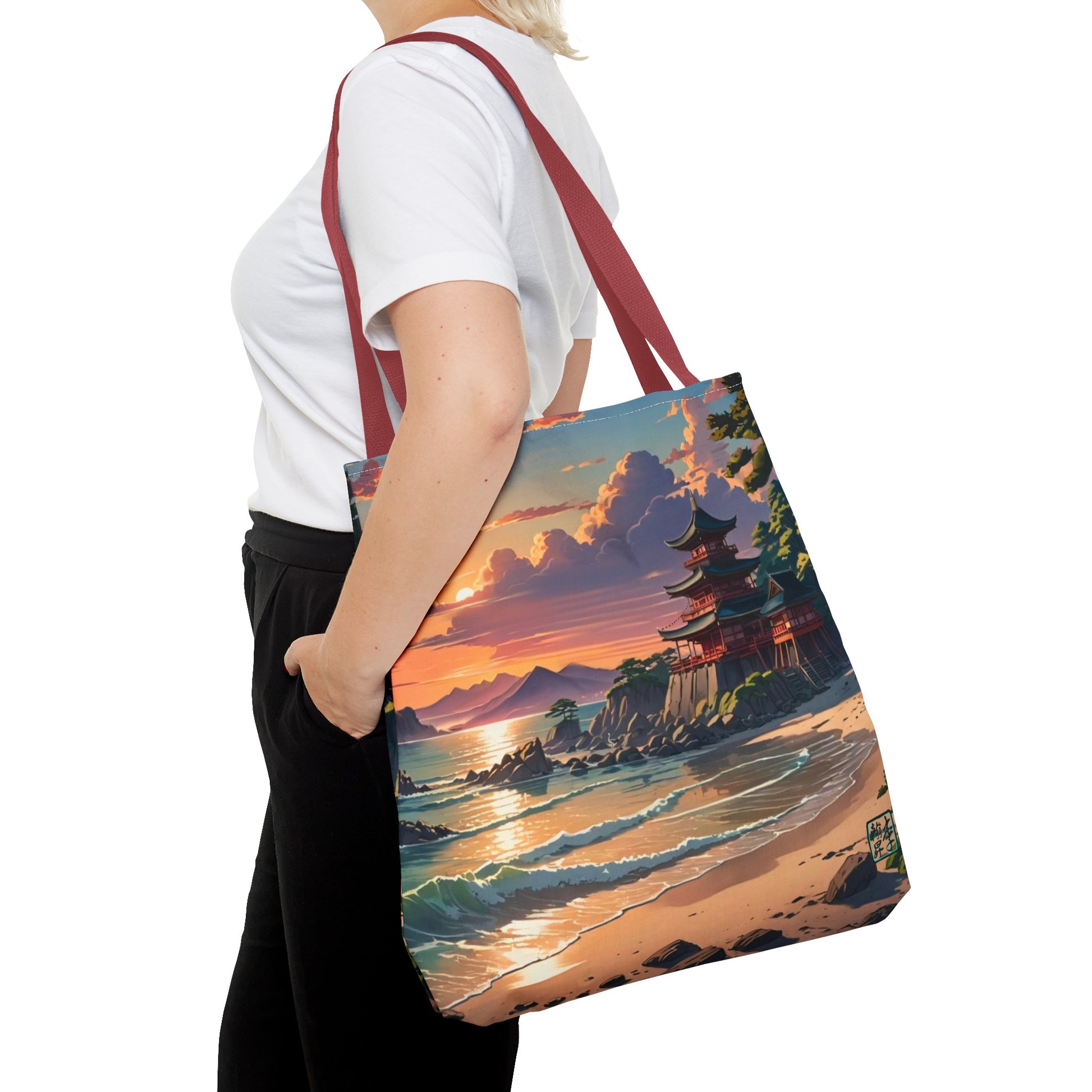 This is the Red 18" x 18" Temple of Peace All-over Print Tote Bag by Lee Hansheng Studios.The illustration shows a setting red/orange sun above clouds,two blue roof,brown/red walled temples on the right on top of the hills,mountains,blue/white waves into sand and a forest to the right.On the bottom right corner is the logo printed in black for the studio and outlined in blue.A lady carries the tote from the shoulder,a white tee,blond short hair,her hand in the black pants pocket walking towards the left.