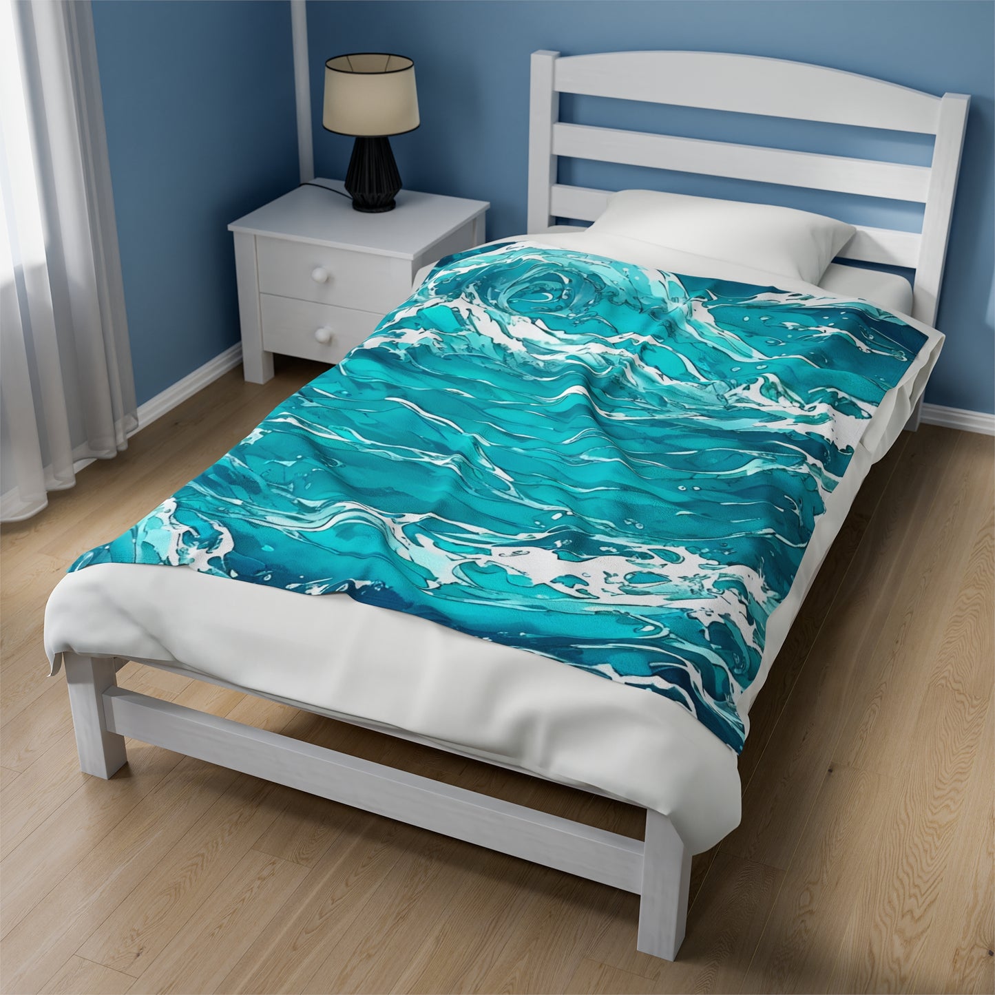 The Swirling Seas design by Lee Hansheng Studios is centered on a twin white wooden bed, dressed with a white duvet and complemented by a white wood slat headboard. The blanket features waves in mixed hues of blues and greens, swirling together with foam caps. A white nightstand in the back left corner holds a black lamp. The room has sky blue walls with white trim, light wood floors, and a window on the left with sheer white curtains that let in soft light.