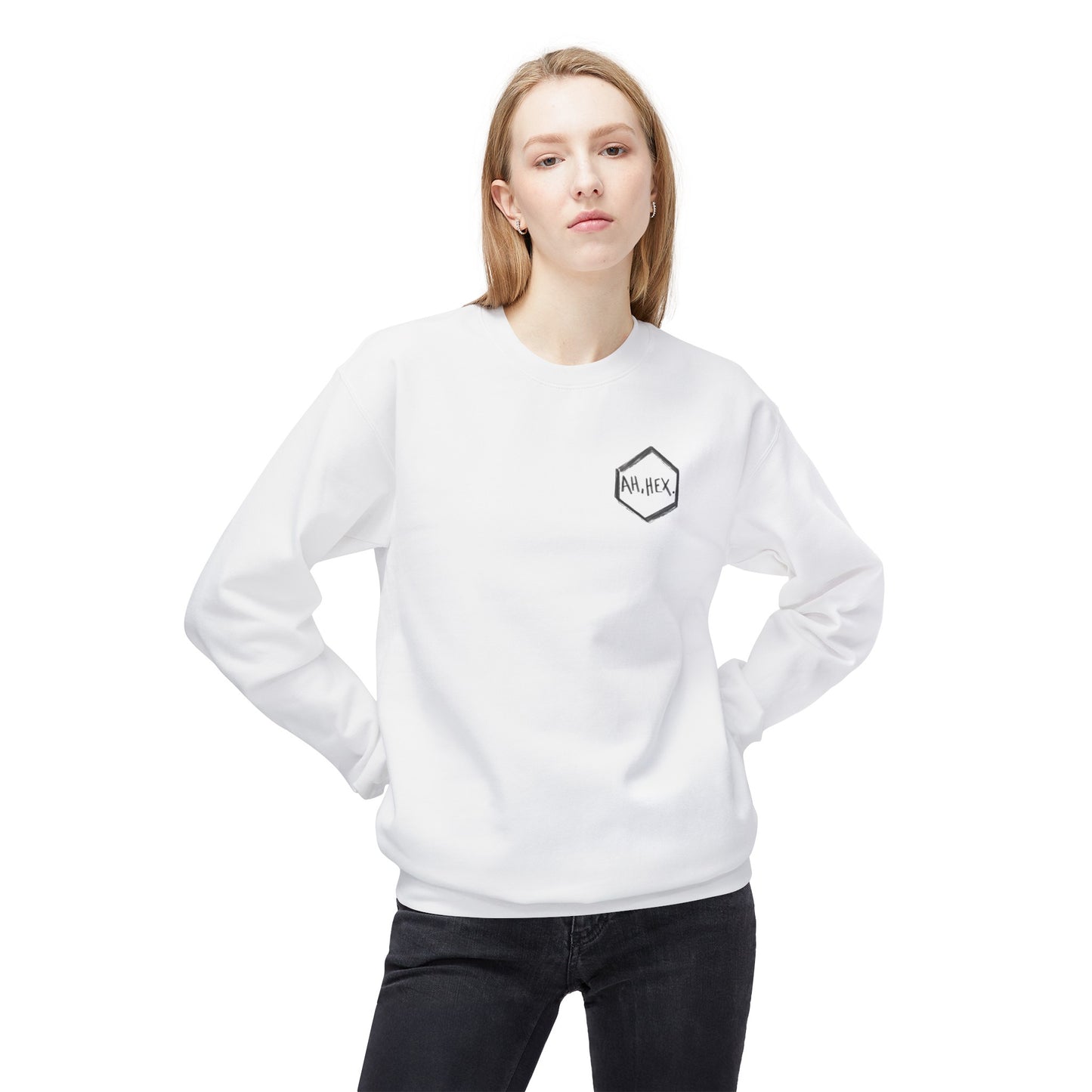 This is the White Ah, Hex Crewneck by Tidy Tea Witch.This showcases the front of the shirt.The illustration is on the upper right of the crewneck printed in black and says. "AH, HEX." in the middle of the sticker.There is no illustration or image on it but is hexsagon shaped. A blonde lady with hair behind her shoulders, tilting her head to the left, has her hands behind her back near the hips wearing black jeans. She is against a white background.
