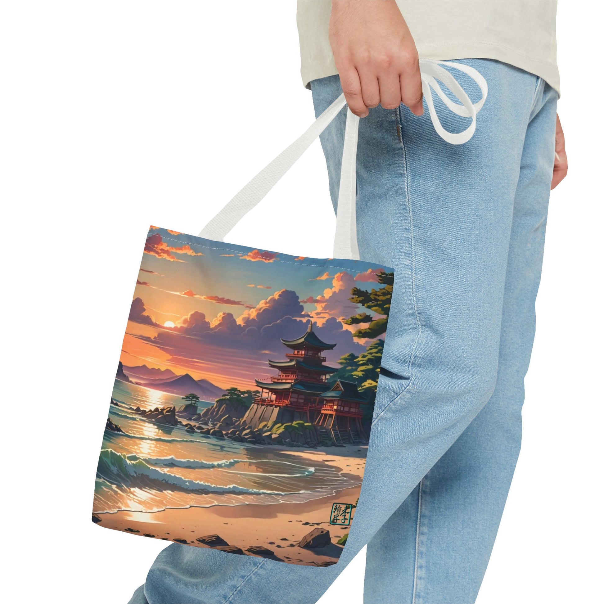 This is the White 16" x 16" Temple of Peace All-over Print Tote Bag by Lee Hansheng Studios.The illustration shows a setting red/orange sun above clouds,two blue roof,brown/red walled temples on the right on top of the hills,mountains,blue/white waves into sand and a forest to the right.On the bottom right corner is the logo printed in black for the studio and outlined in blue. The image is of a man wearing white tee, light jeans and right hand is holding the tote from waist down.