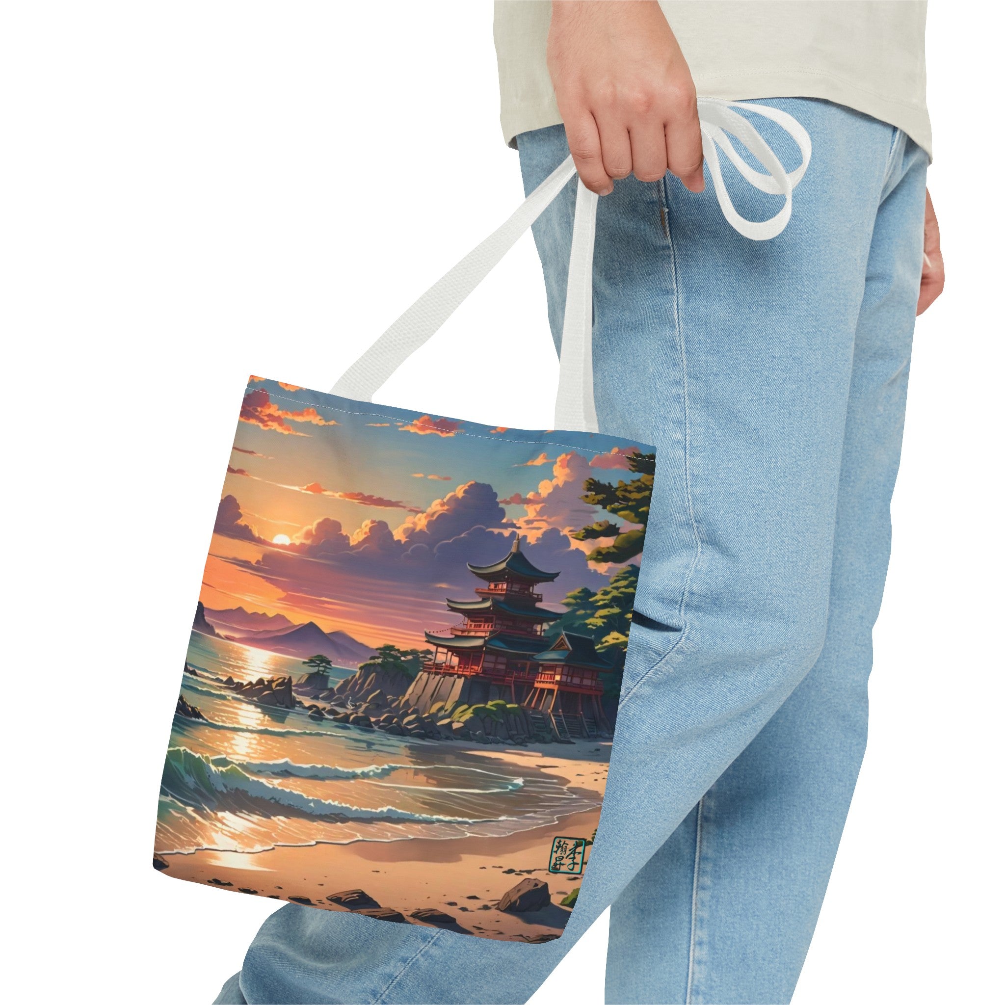 This is the White 16" x 16" Temple of Peace All-over Print Tote Bag by Lee Hansheng Studios.The illustration shows a setting red/orange sun above clouds,two blue roof,brown/red walled temples on the right on top of the hills,mountains,blue/white waves into sand and a forest to the right.On the bottom right corner is the logo printed in black for the studio and outlined in blue. The image is of a man wearing white tee, light jeans and right hand is holding the tote from waist down.