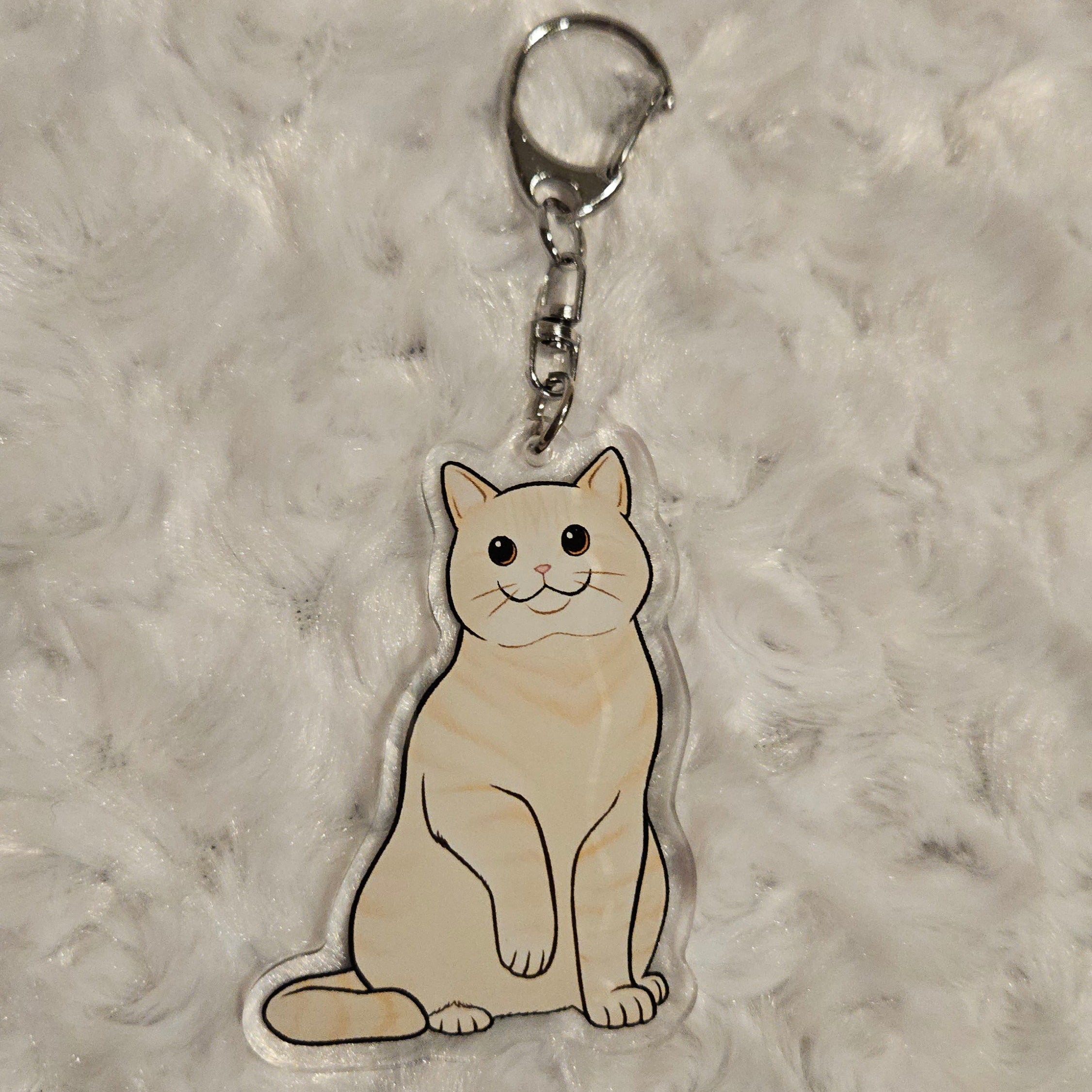 Keychain with a cat design on a textured gray surface
