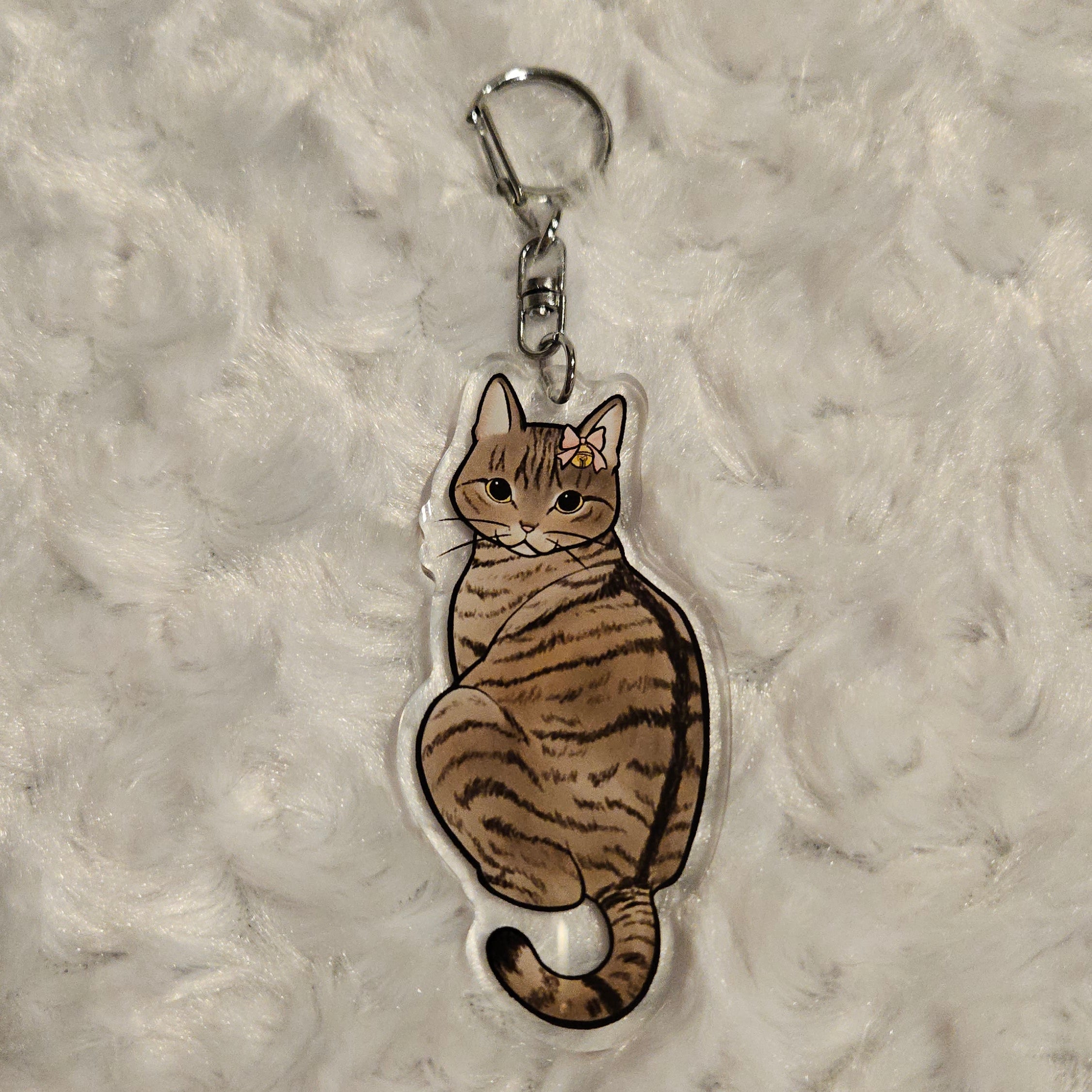 Cat-shaped keychain on a textured gray surface