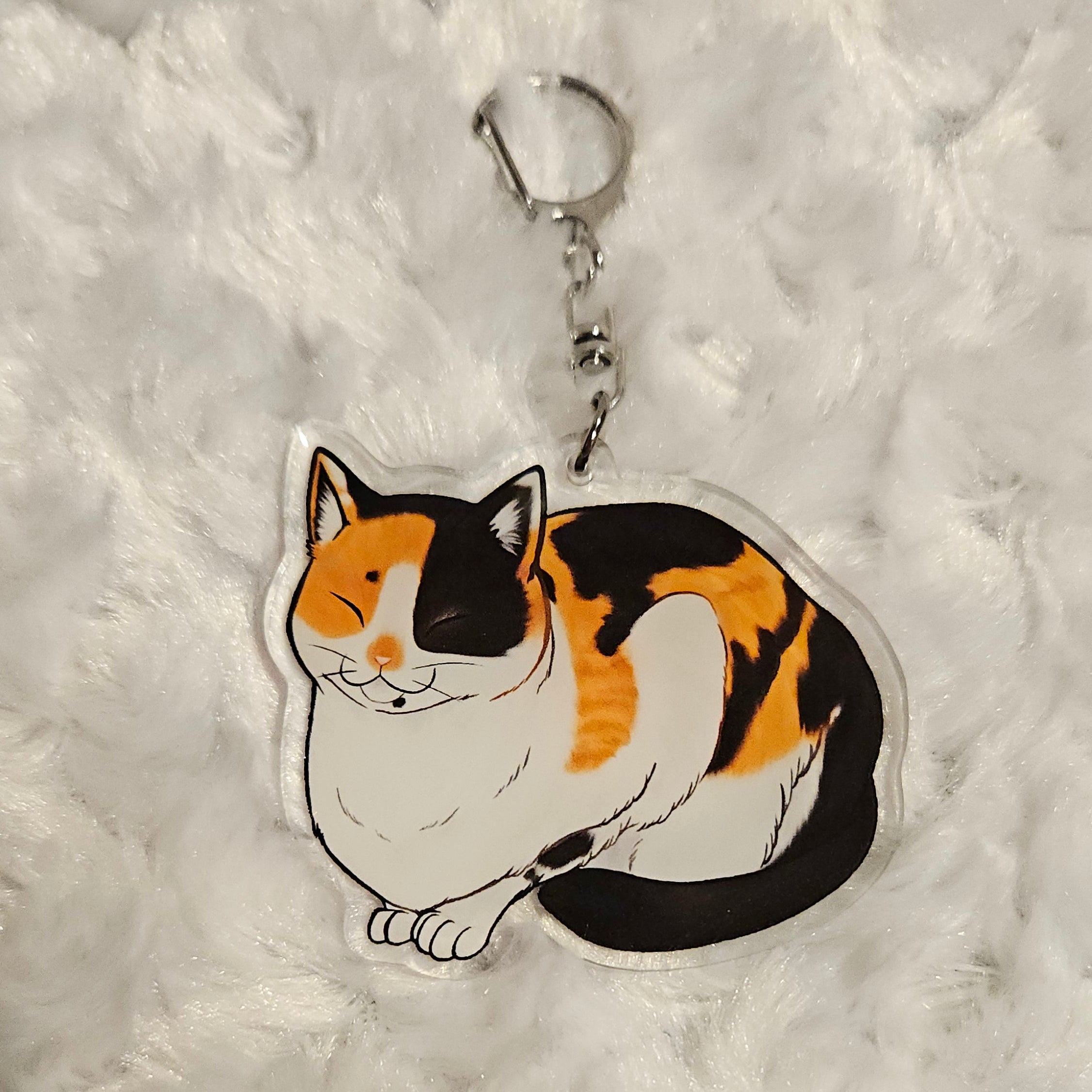 Cat-shaped keychain on a textured gray surface