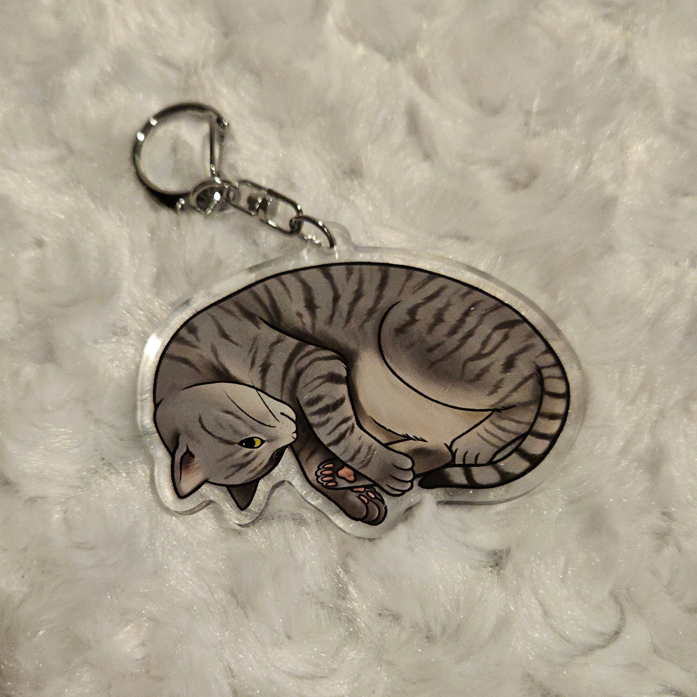 Keychain with a design of a cat on a textured gray background