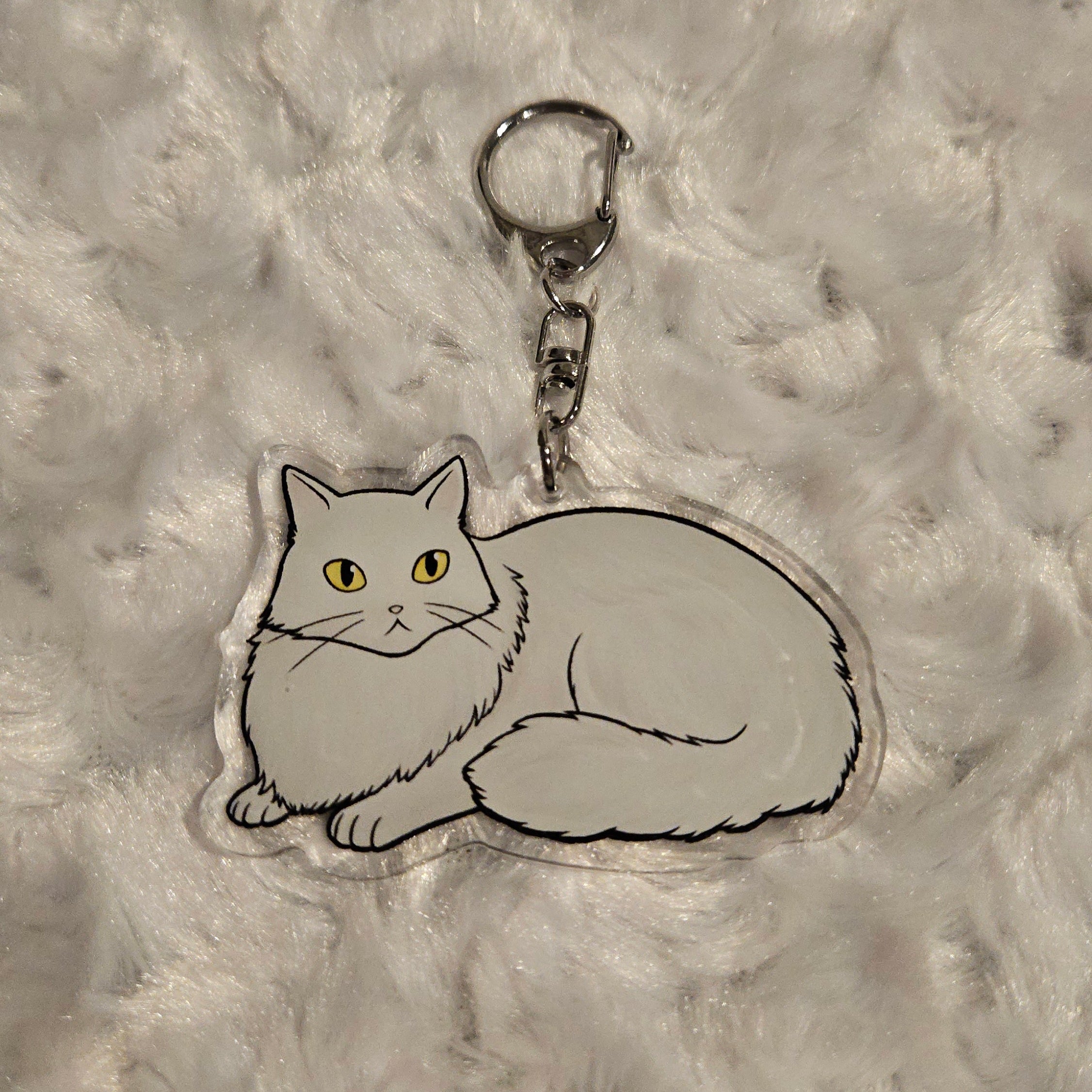 Cat-shaped keychain on a textured gray background