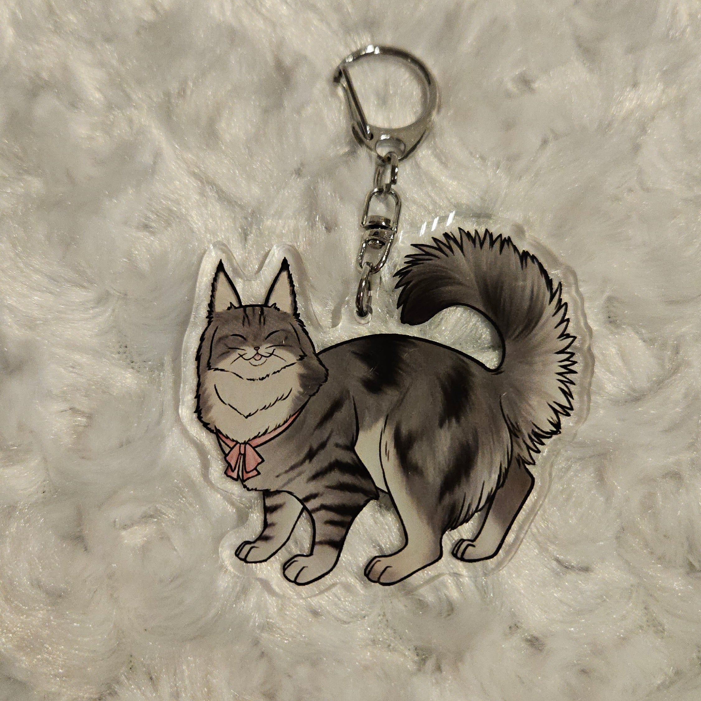 Keychain with a design of a cat and bow on a textured gray background