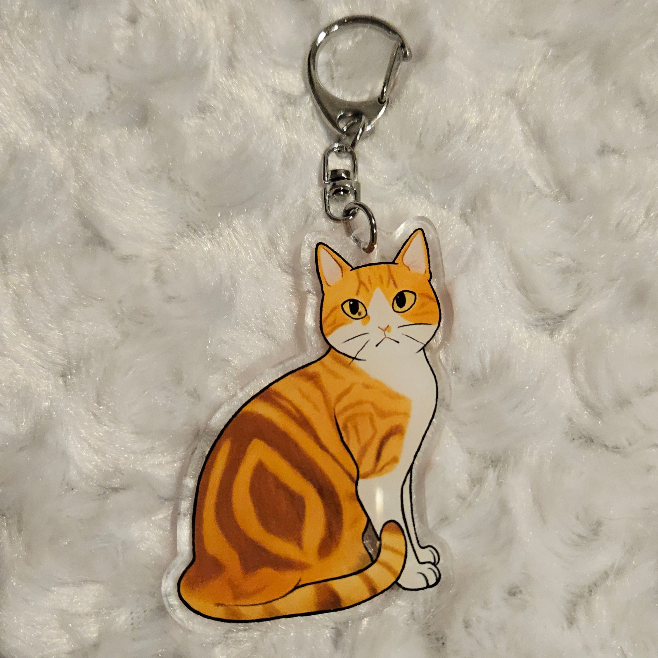 Cat-shaped keychain on a textured gray surface
