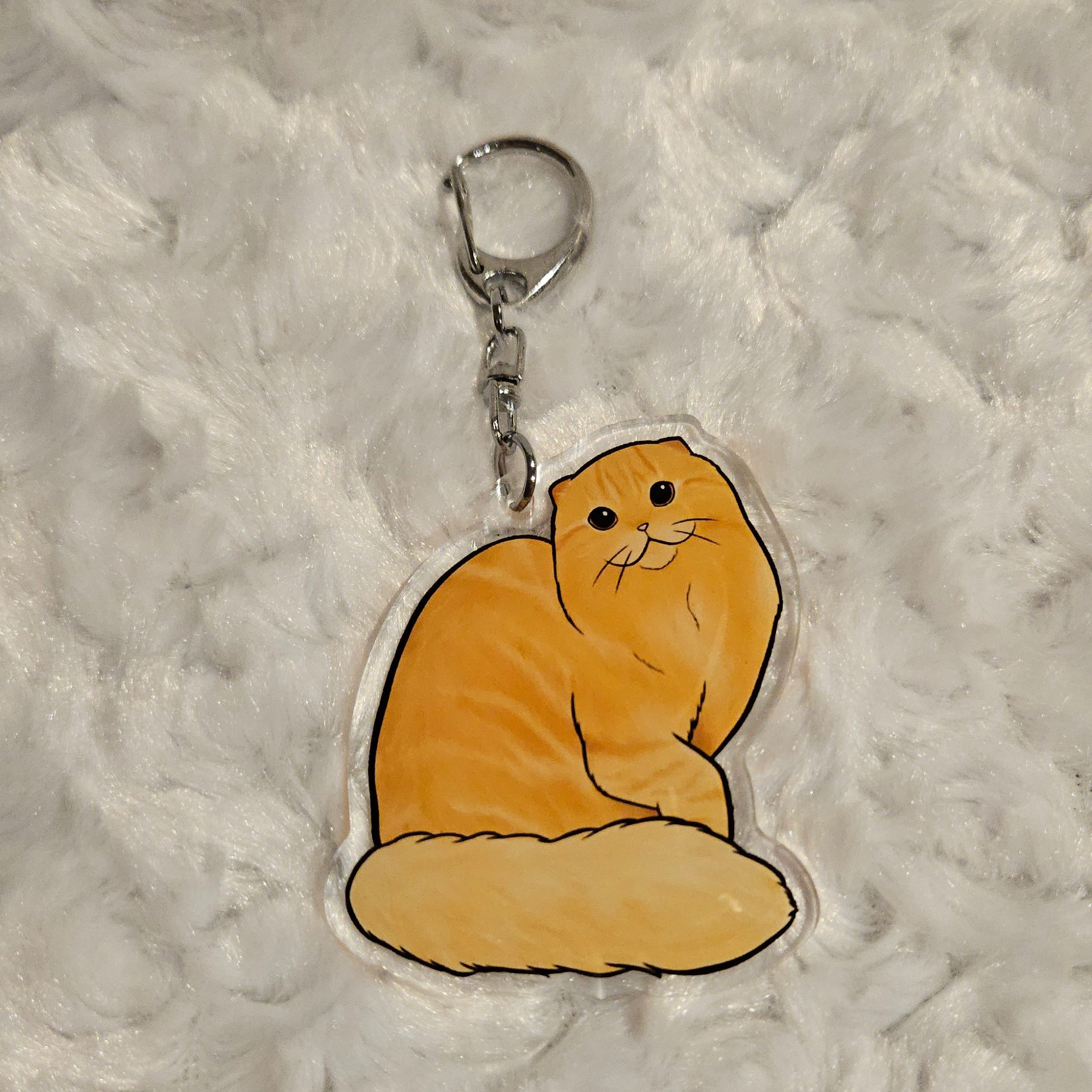 Keychain with a cartoon bear design on a textured gray background