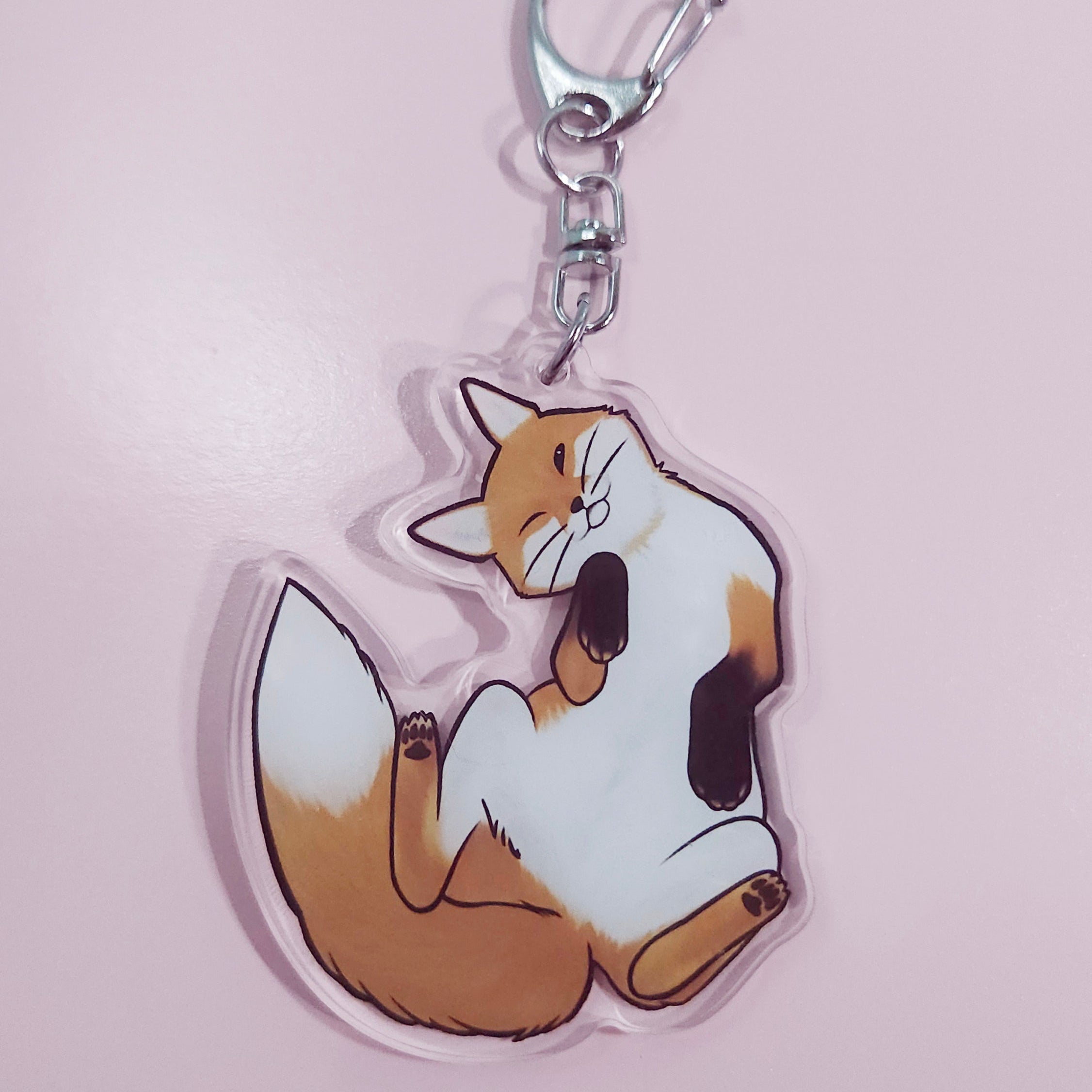 Cartoon fox keychain on a pink background
