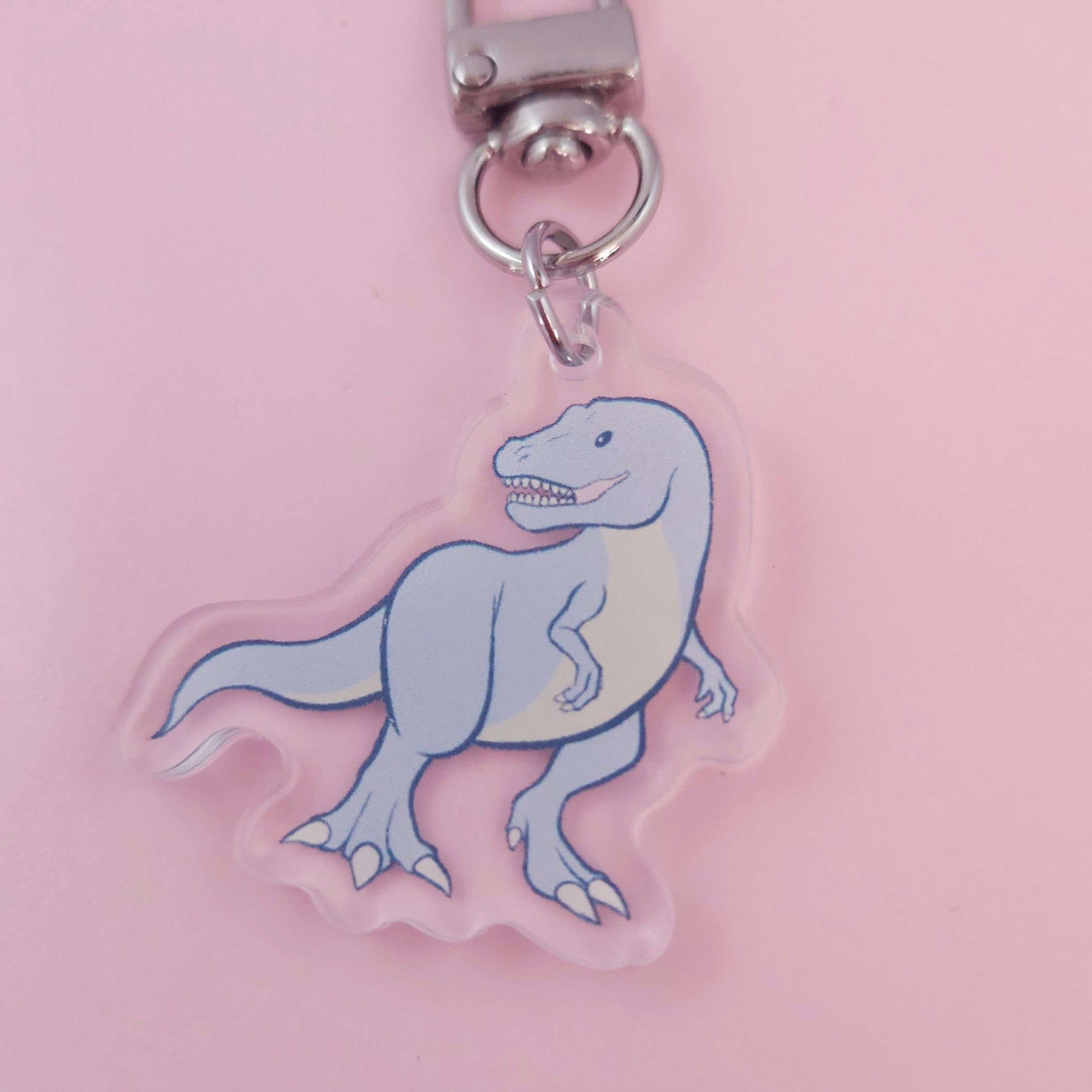 Keychain with a cartoon shark design on a pink background